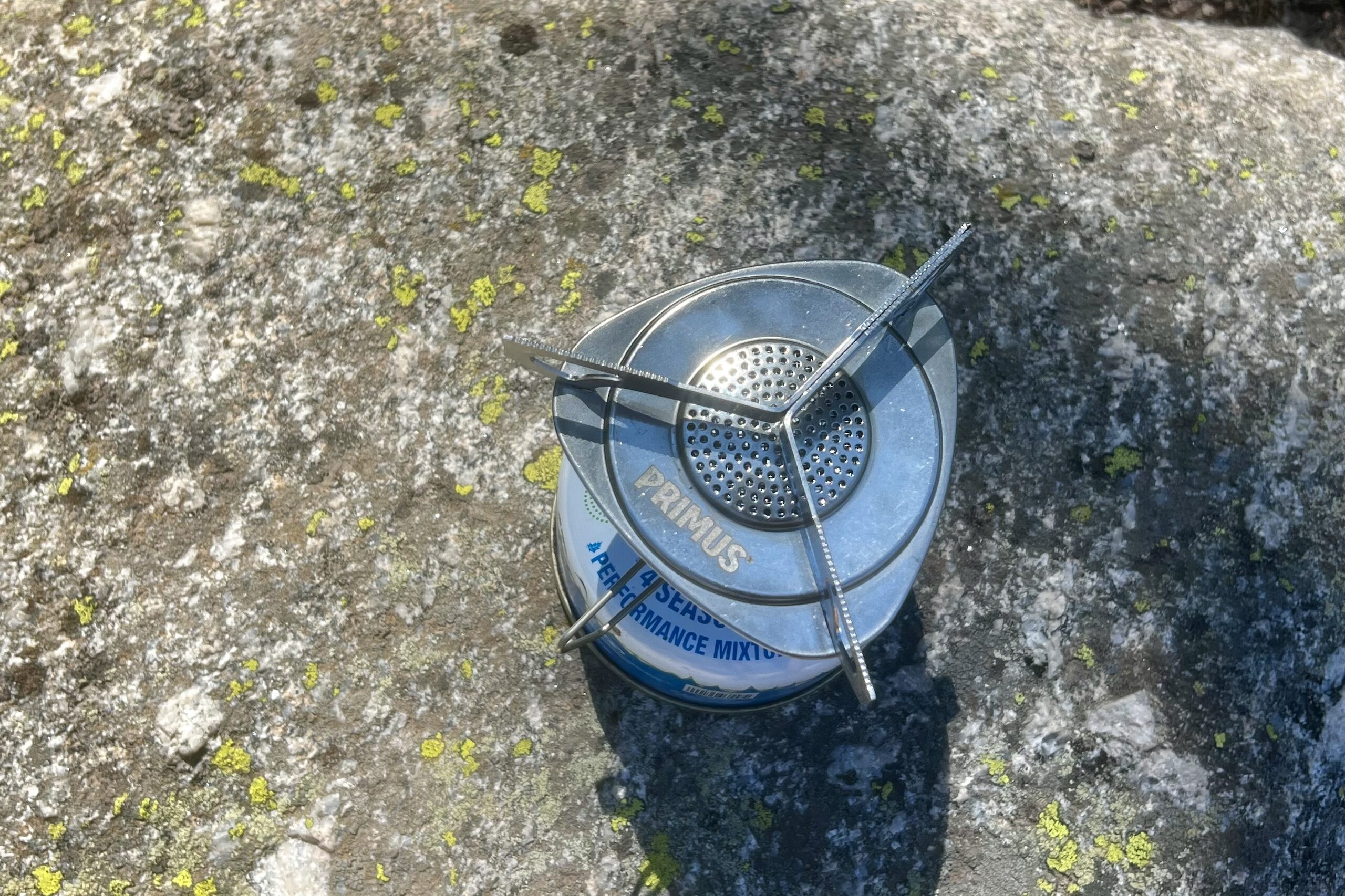 An arial shot of the Primus Essential Trail stove on a fuel canister, sitting on a rock.