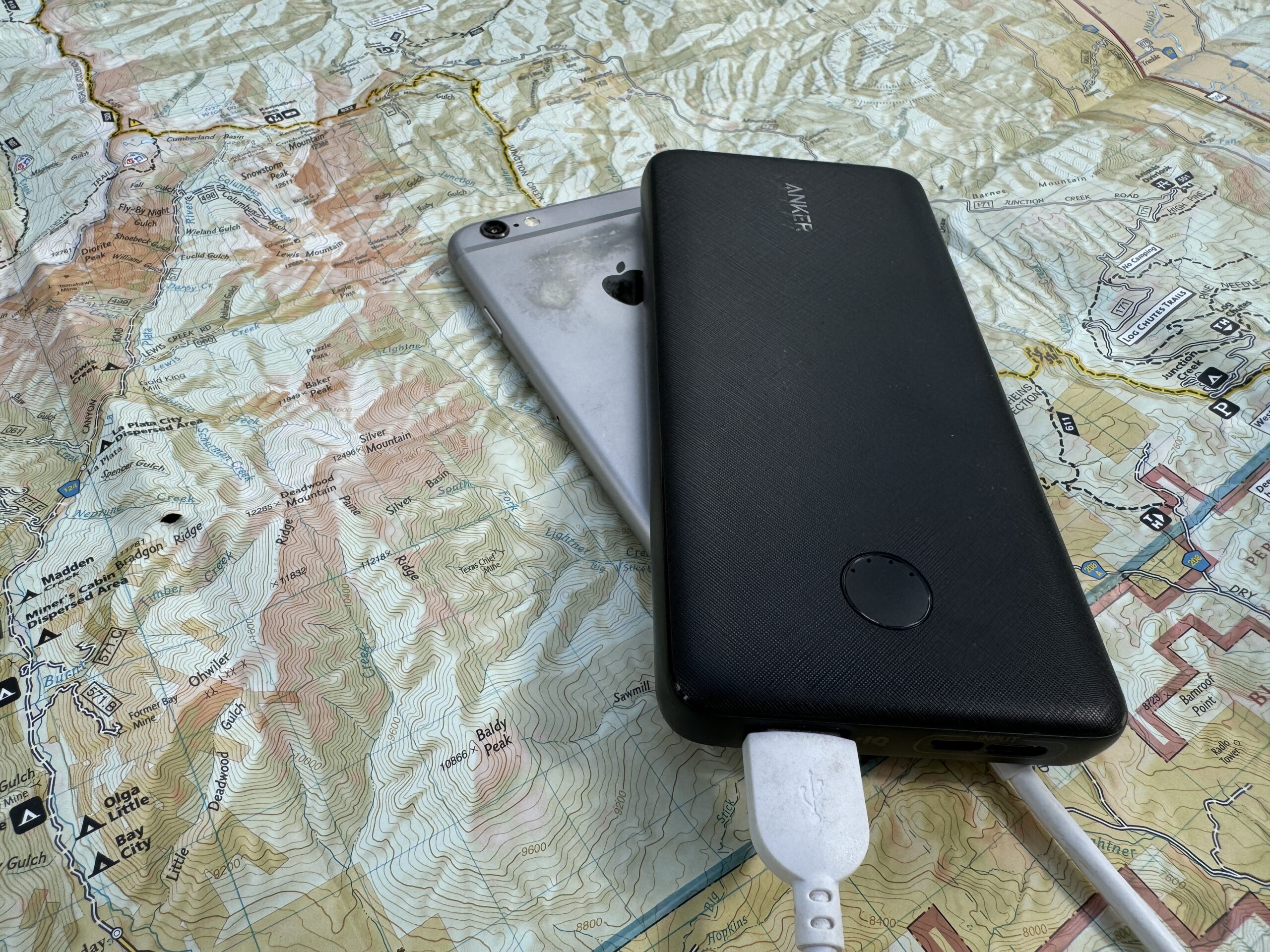 The Anker power bank and a phone sit on a map.