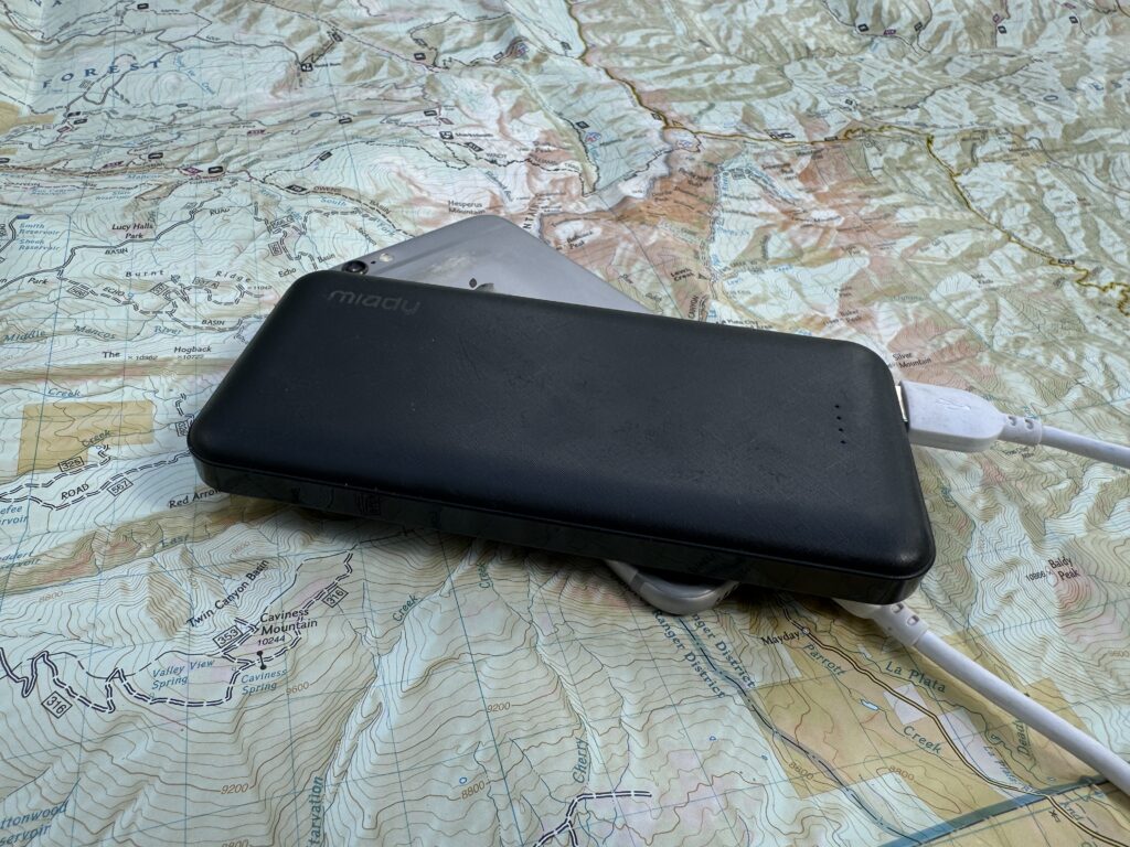 The Miady power bank and a phone sit on a map.