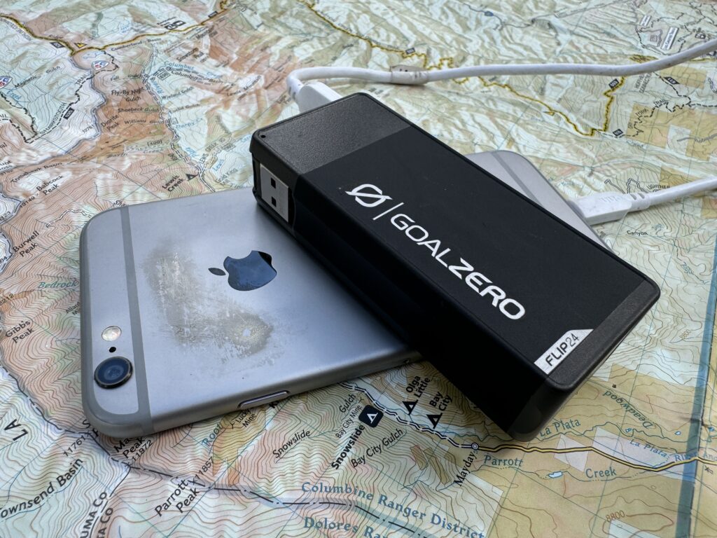 The Goal Zero power bank and a phone sit on a map.