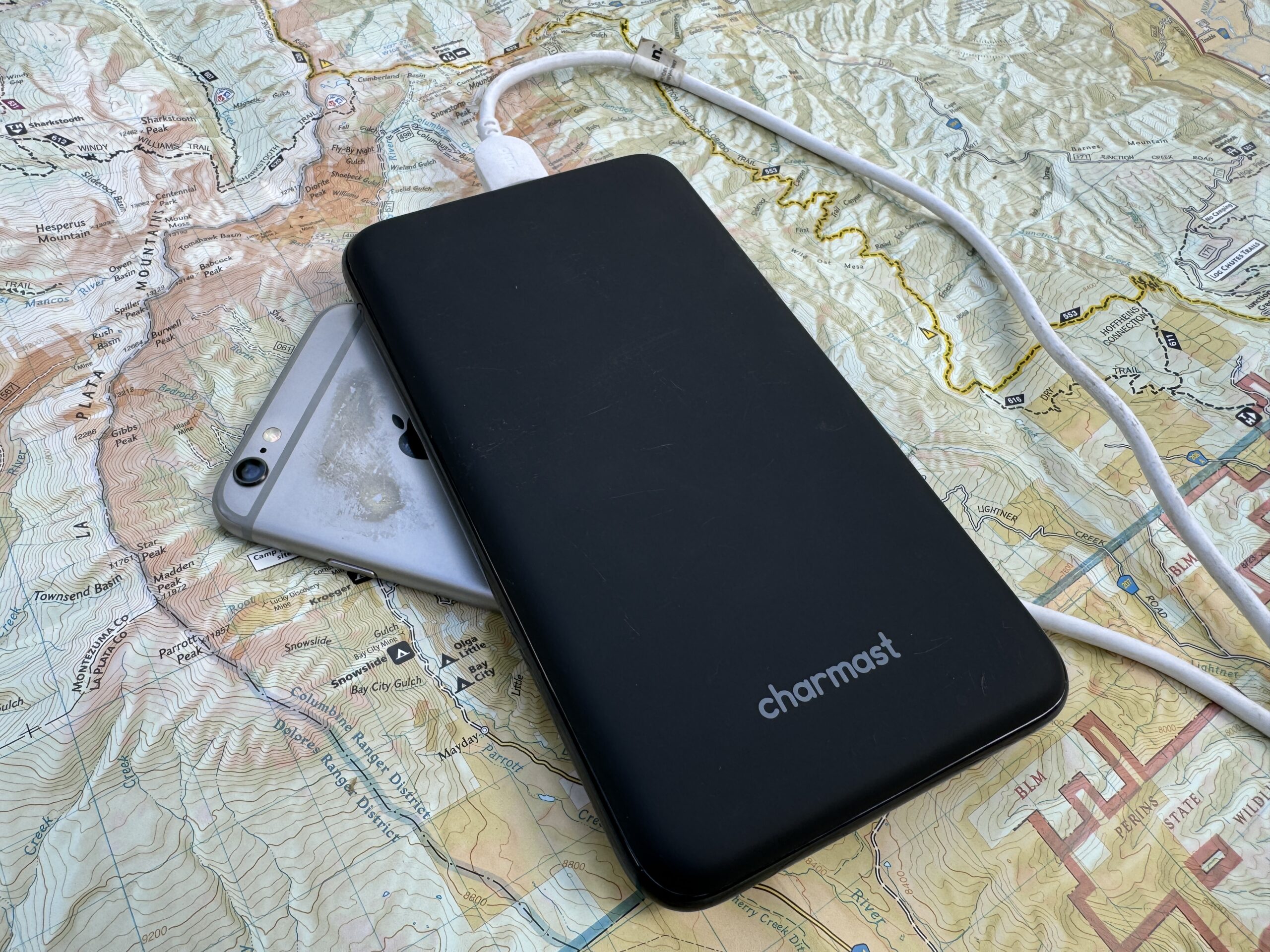 The Charmast power bank and a phone sit on a map.