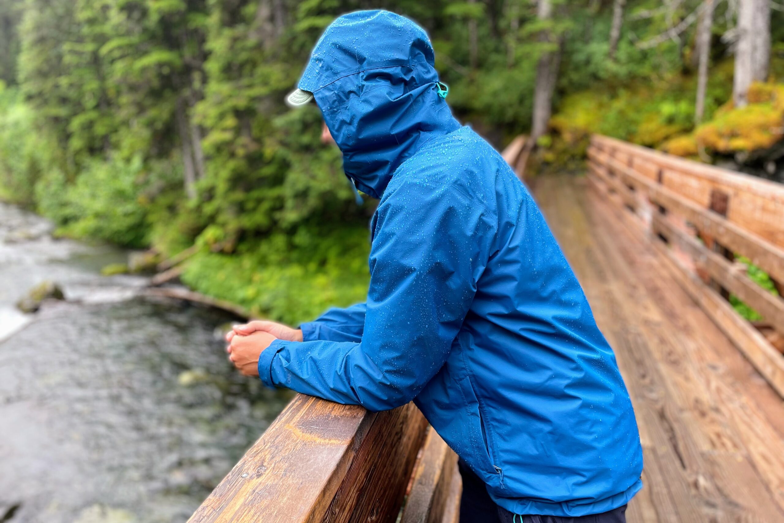 A man stands on a bridge over a river.