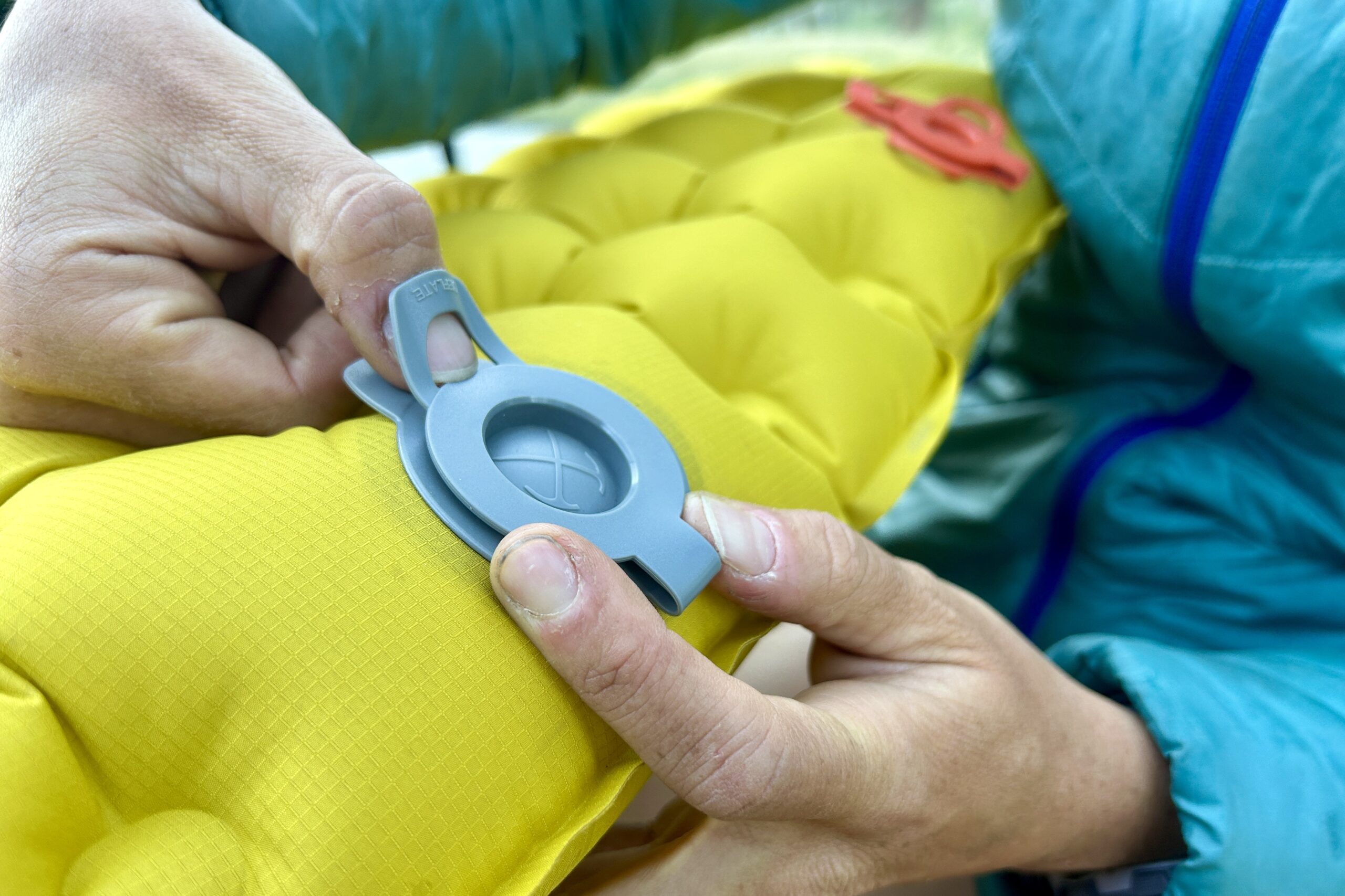 Close up of a person's hands opening a single valve on the REI Helix.