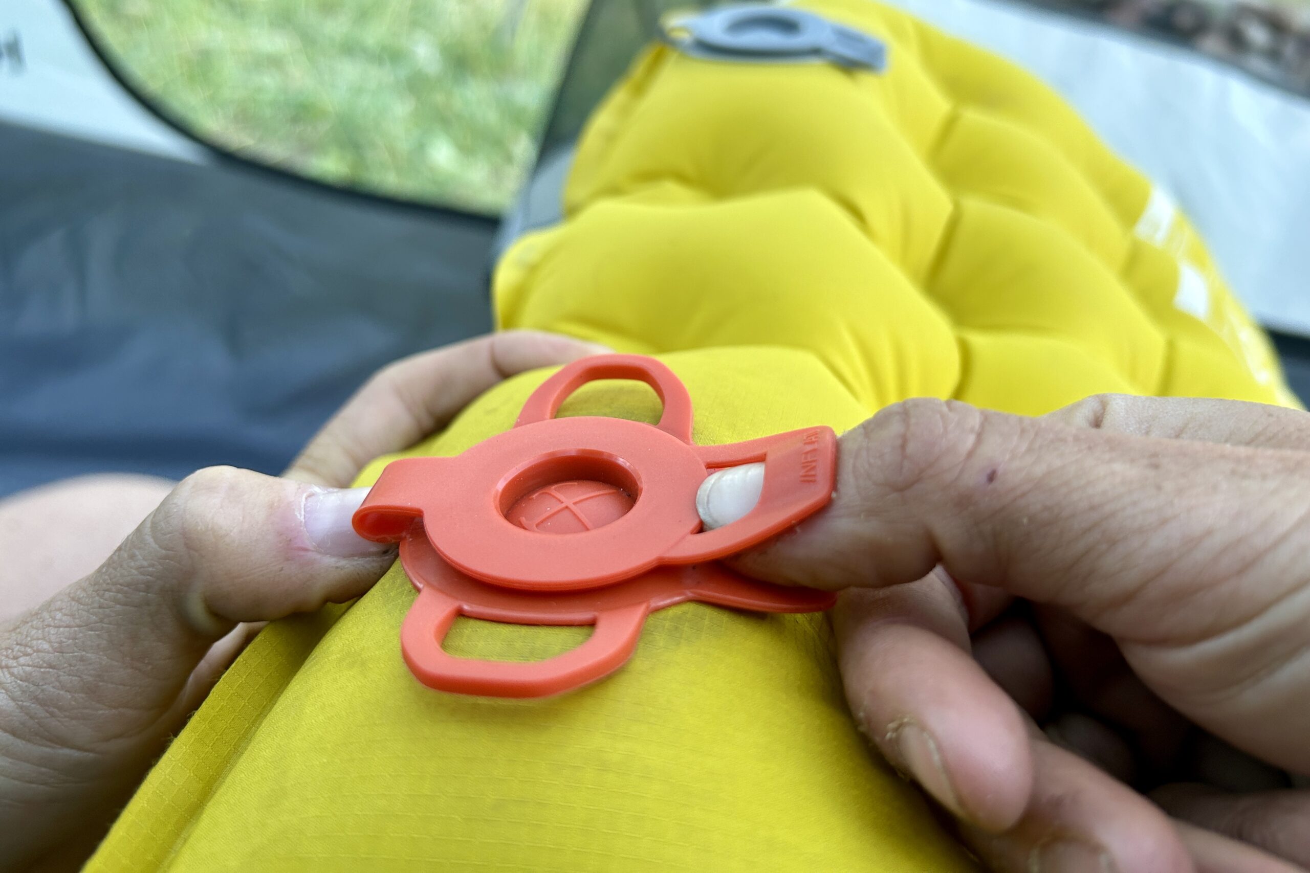 Close up of a person's hands opening a single valve on the REI Helix.