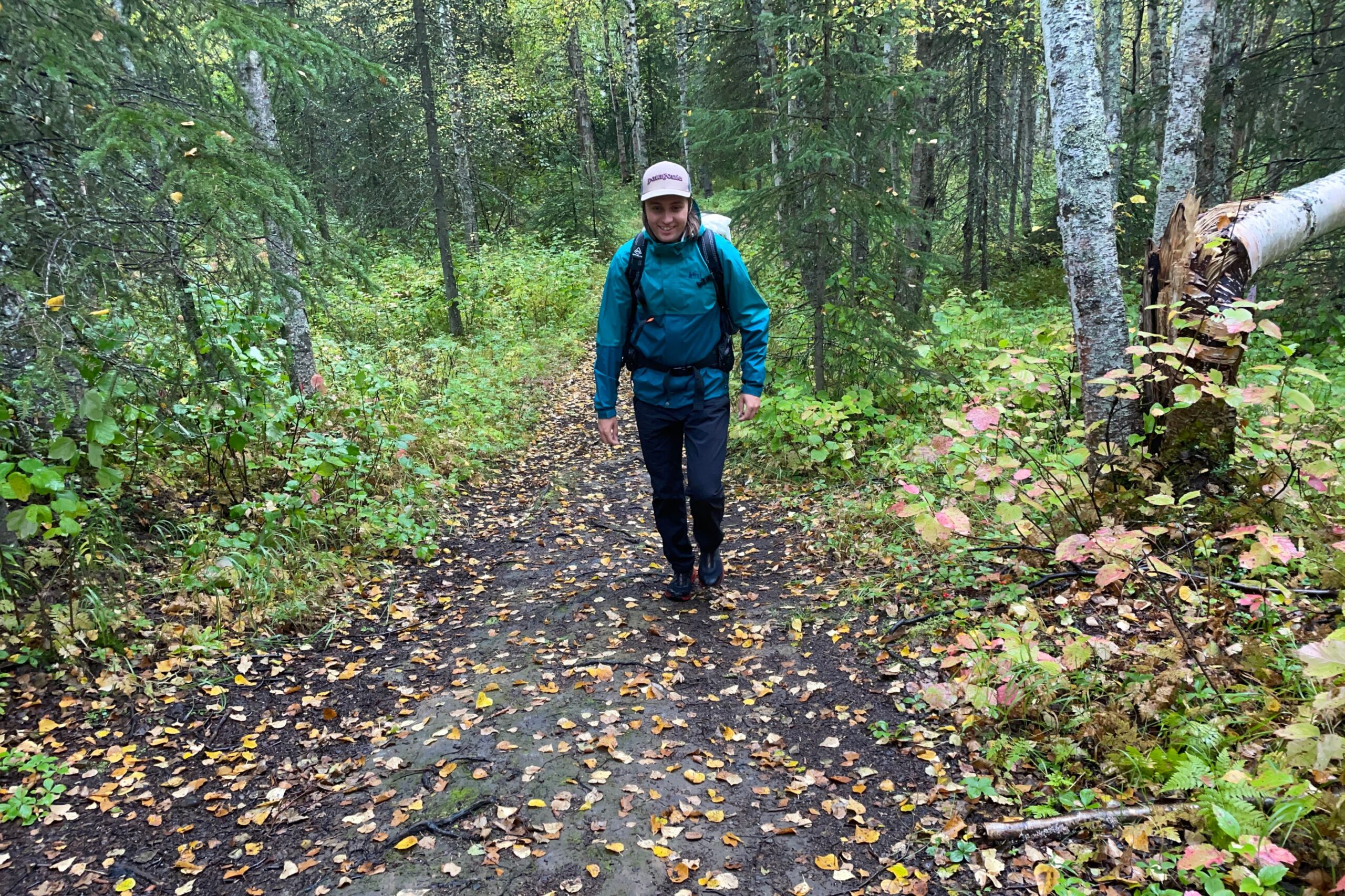 A man hikes uphill through fall foliage