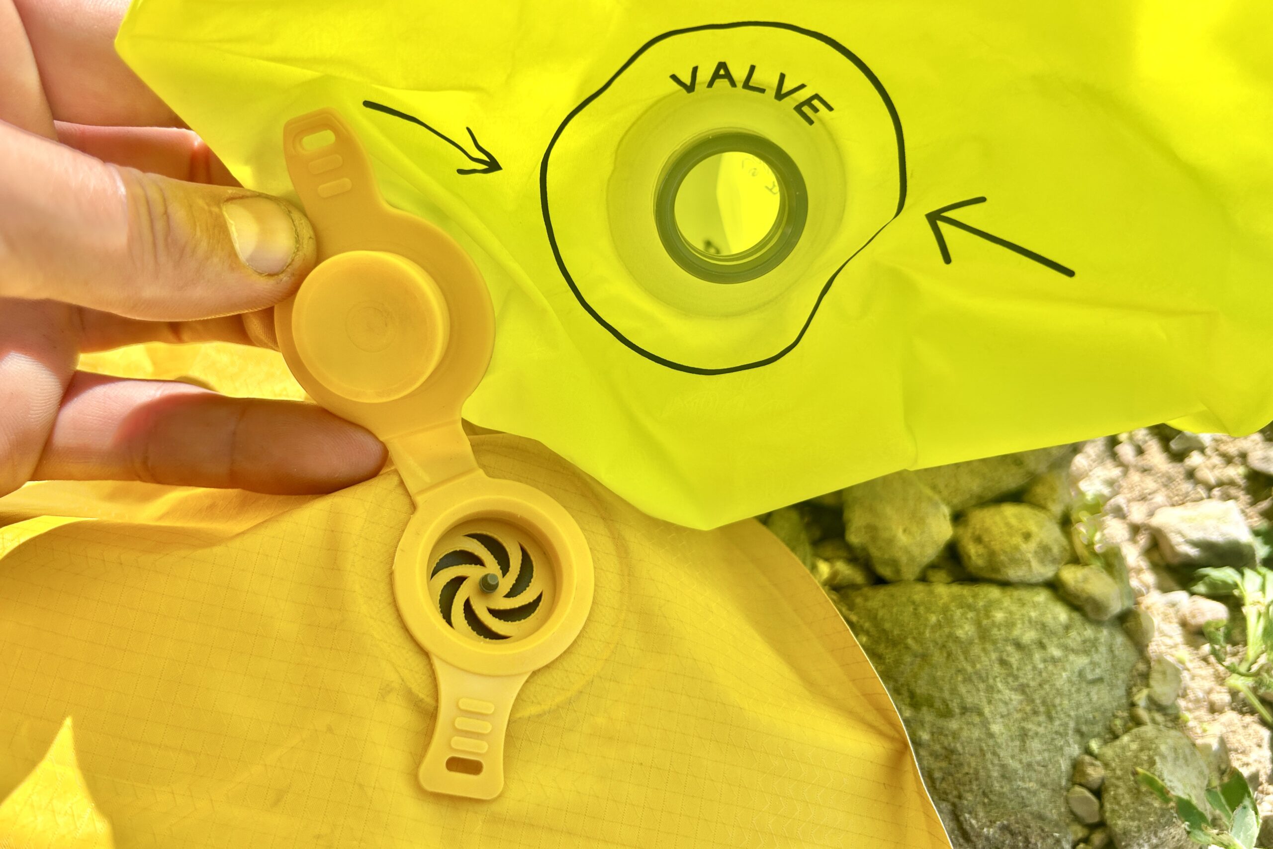 Close up of a pump sack valve and the sleeping pad valve it attaches to.