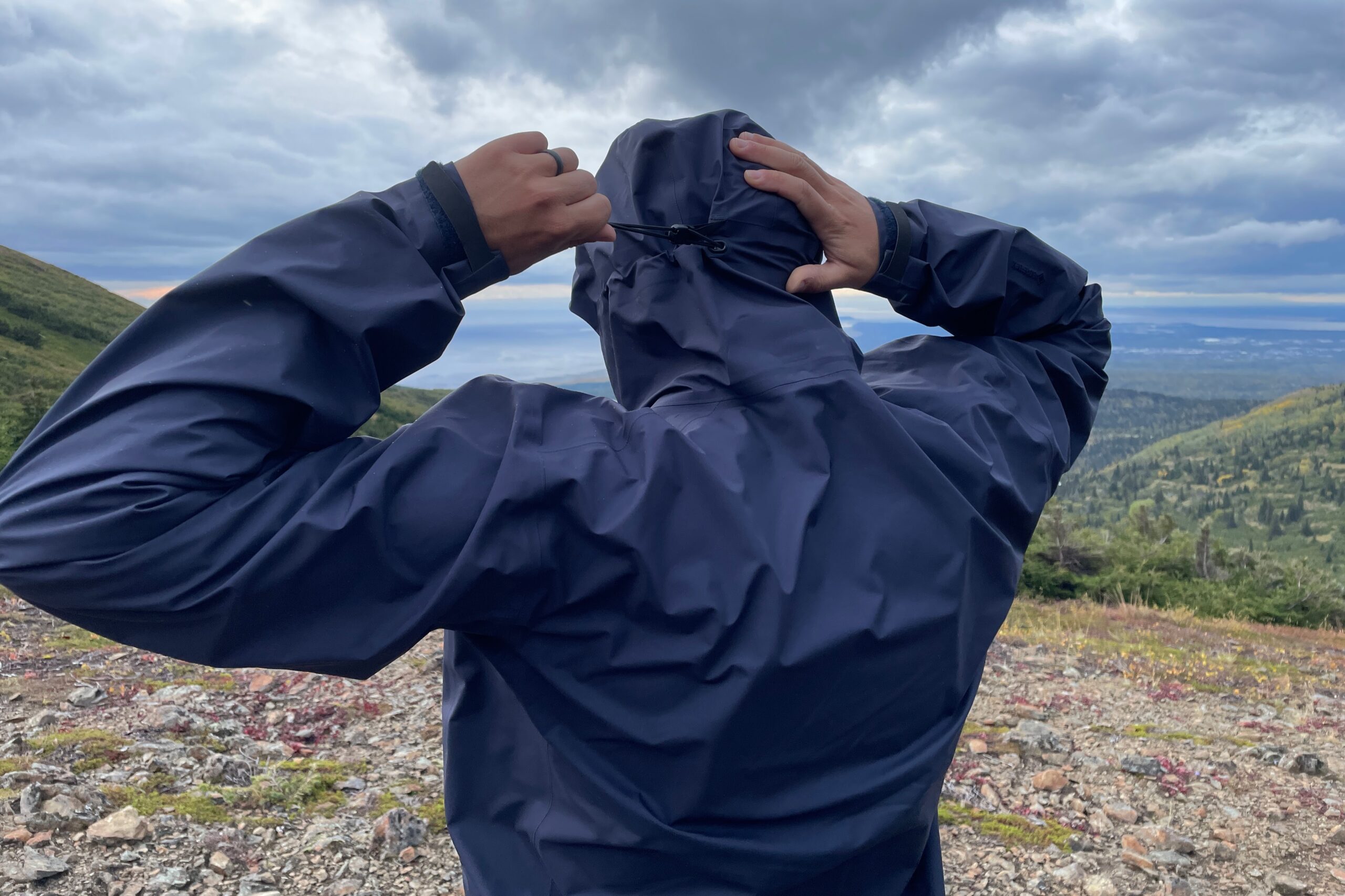 A man cinches the hood on his rain jacket.