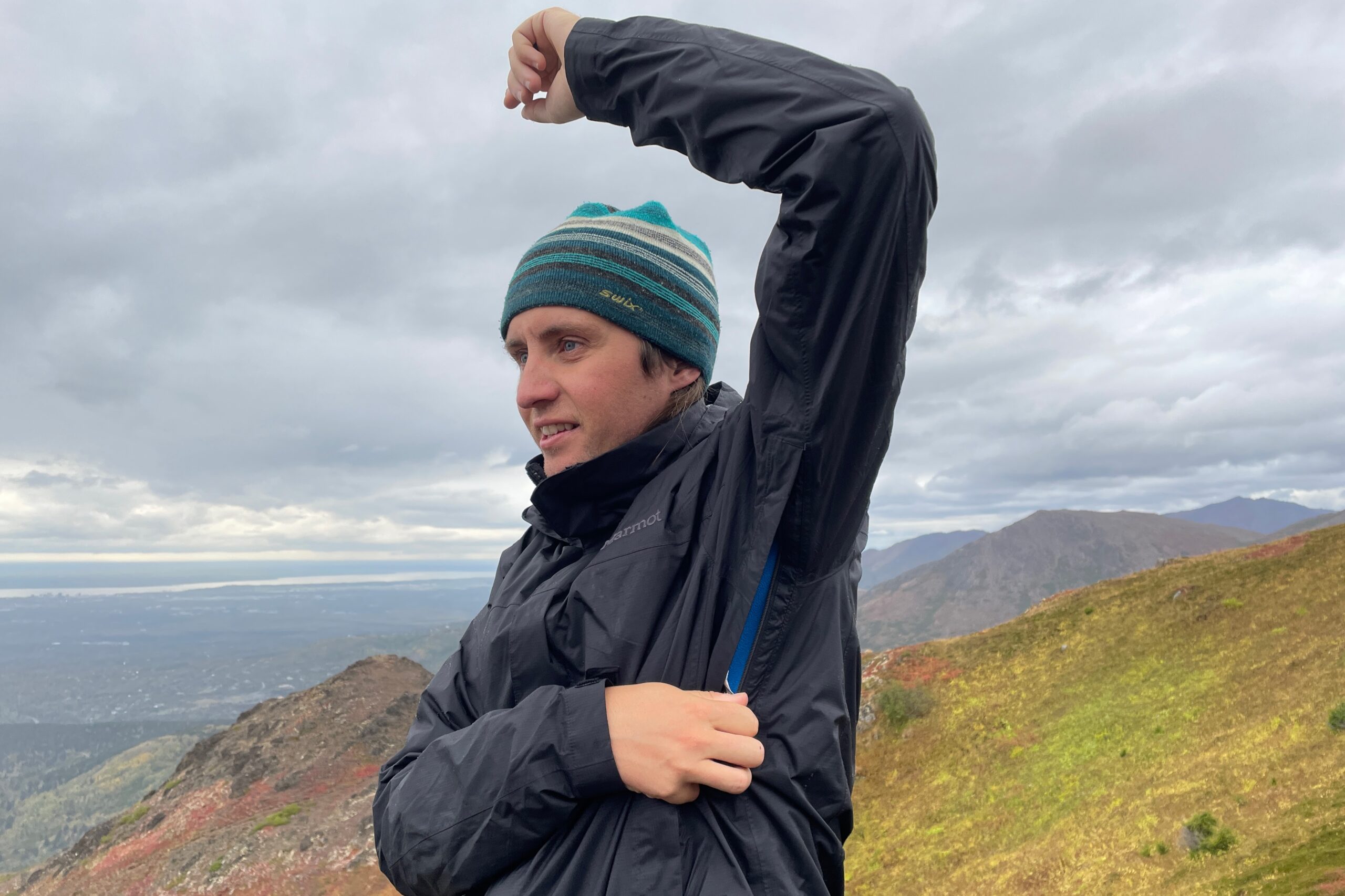 A man unzips the vents of his rain jacket