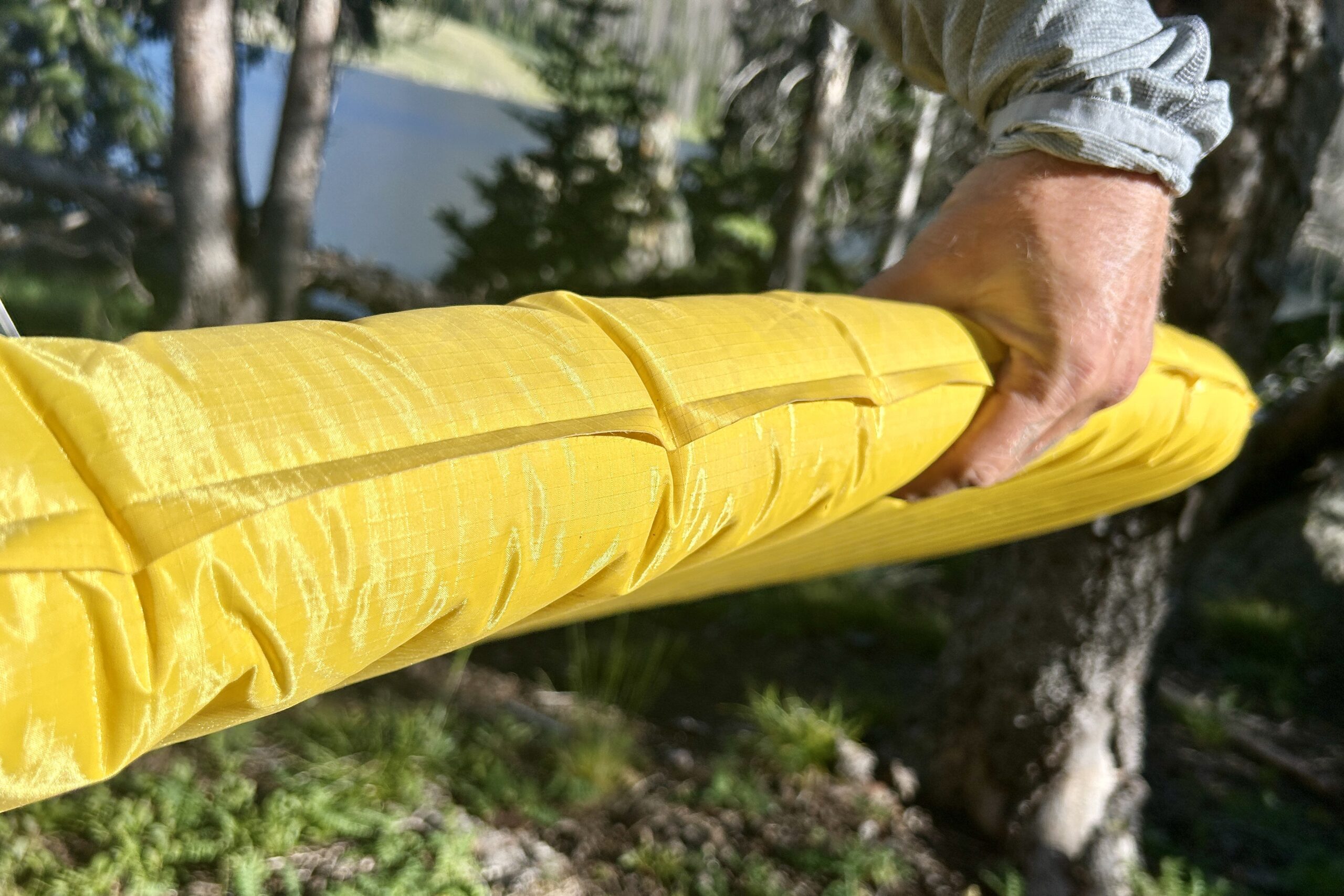 A person grips the side of a sleeping pad.