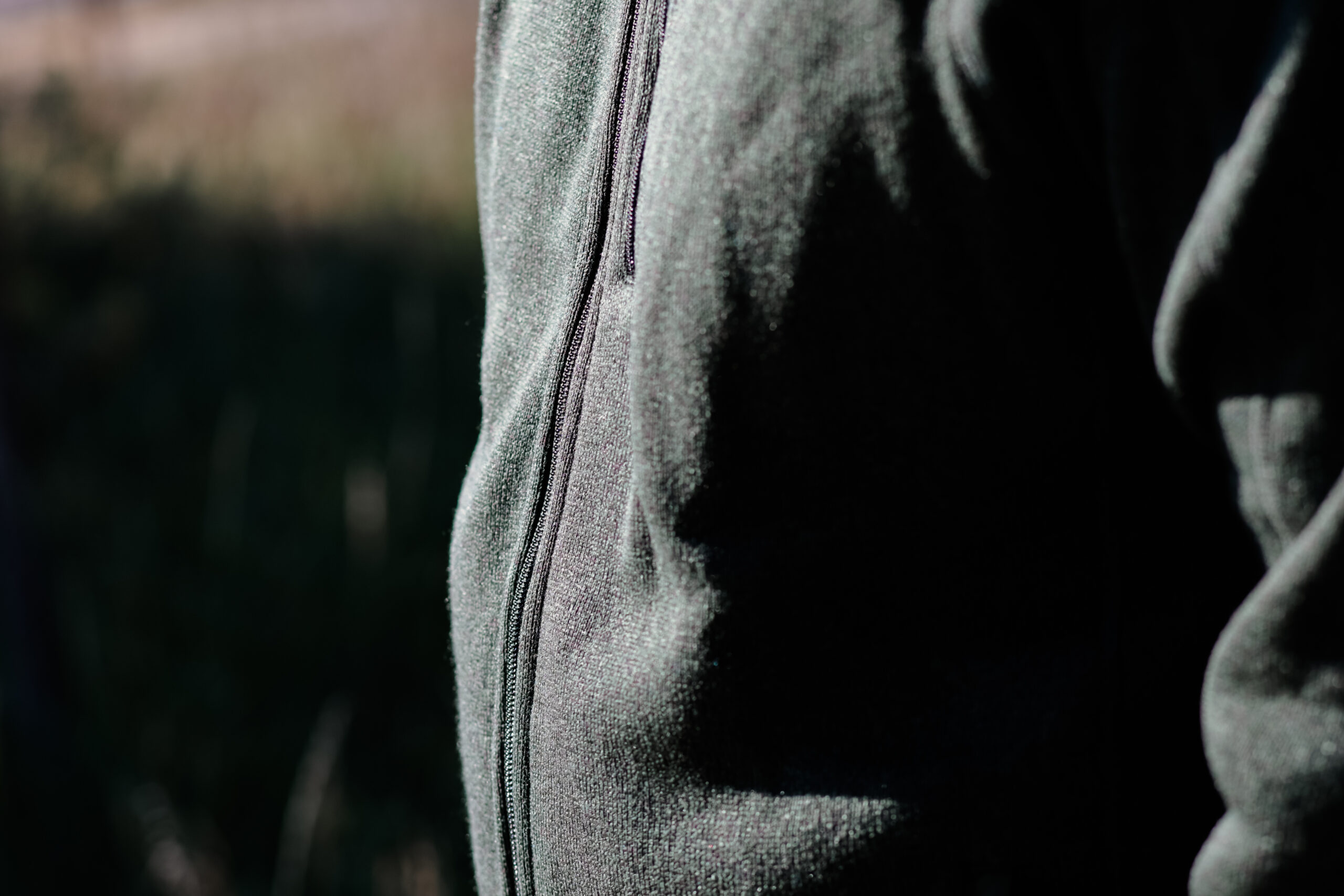 The zipper on a green fleece.