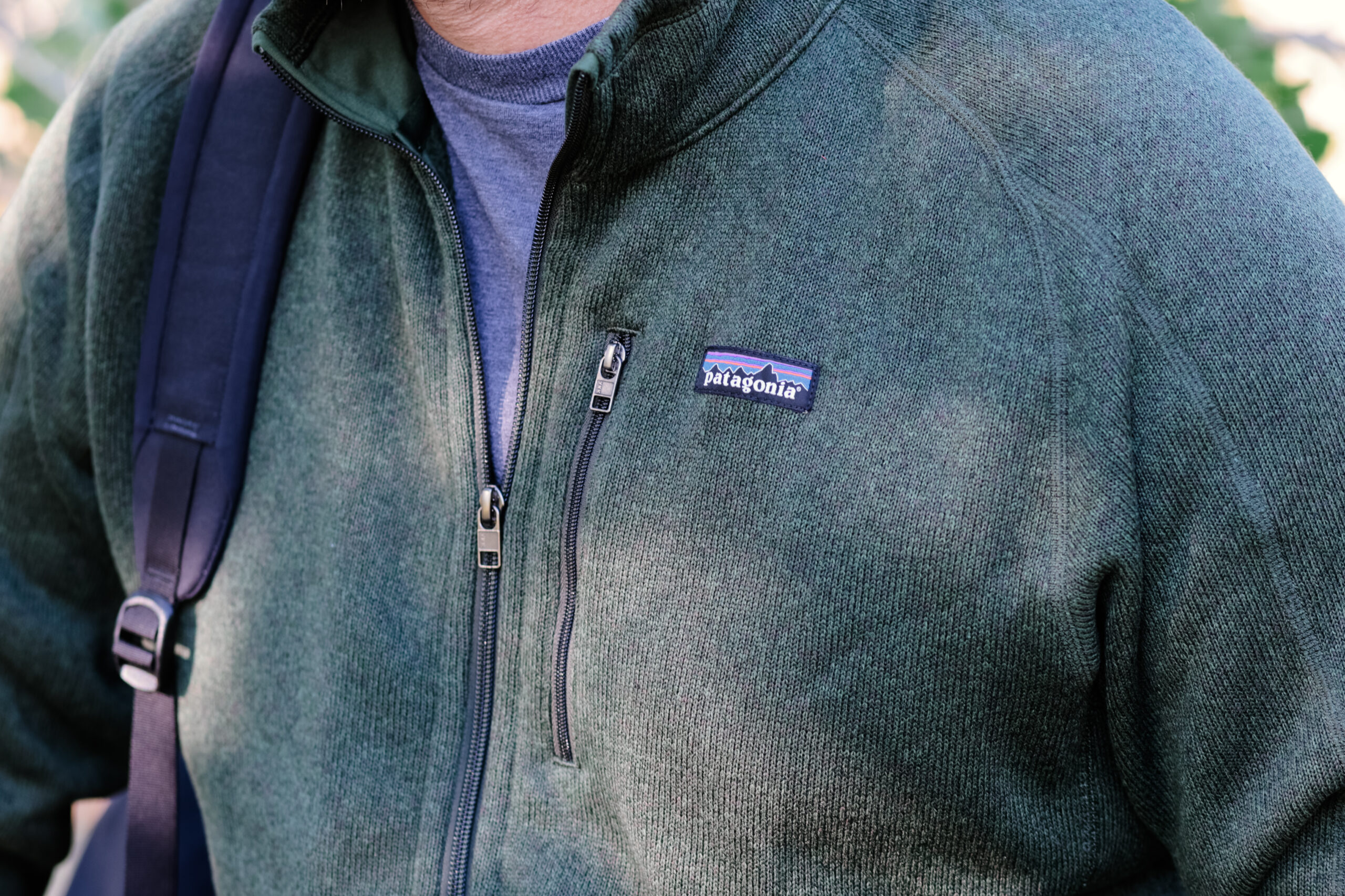 A close up of a fleece pocket on the chest with a backpack strap on the other shoulder.