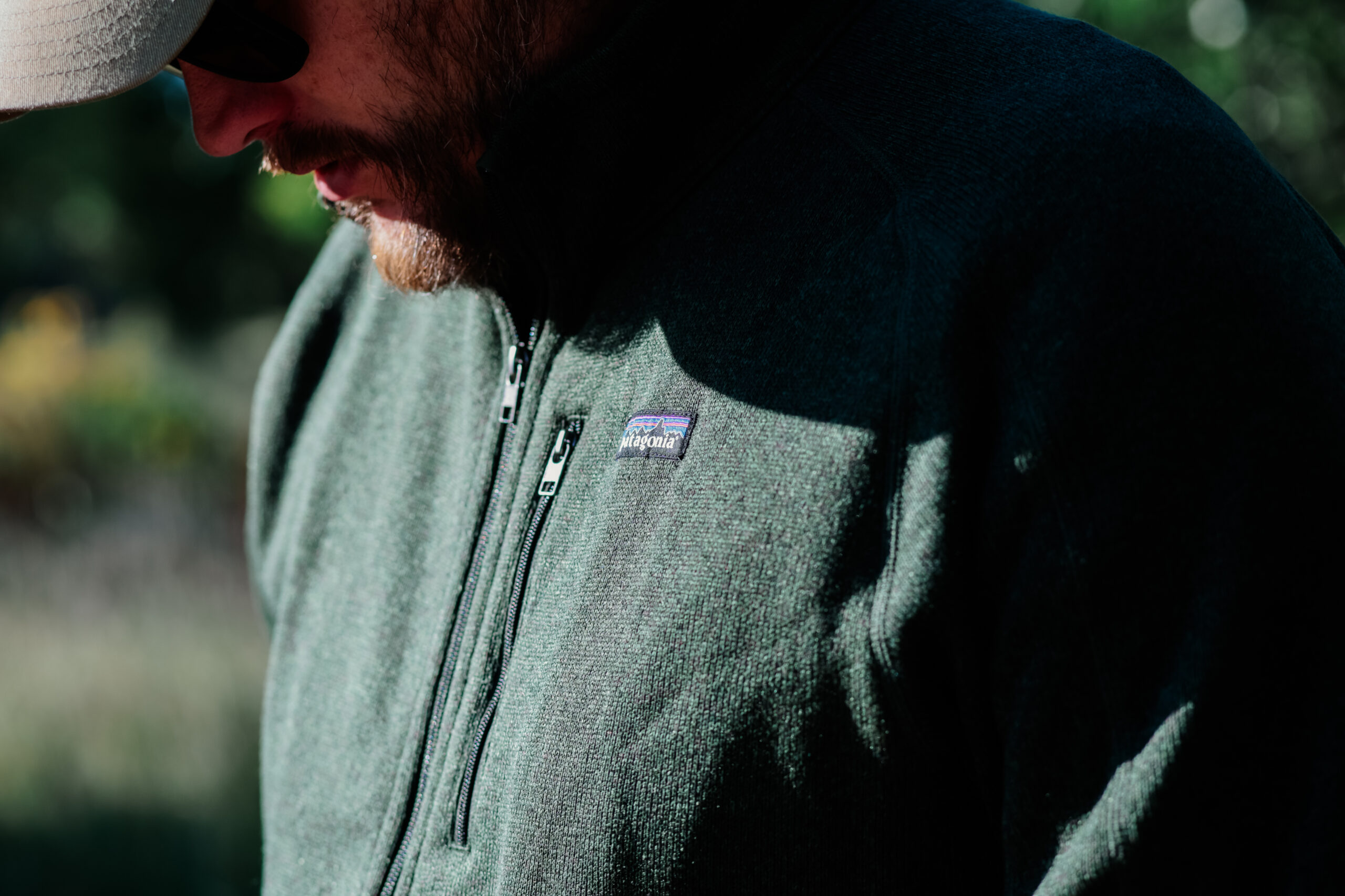 A close up of a Patagonia logo on a fleece jacket while a man looks down.