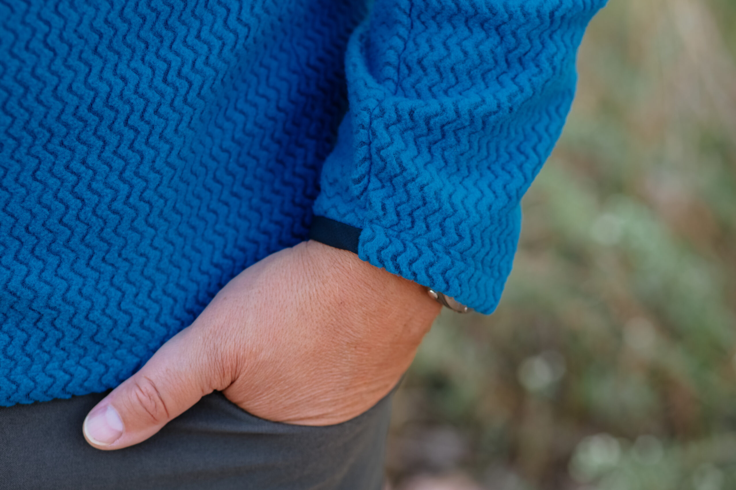 The cuff of a fleece with a hand in the pocket.