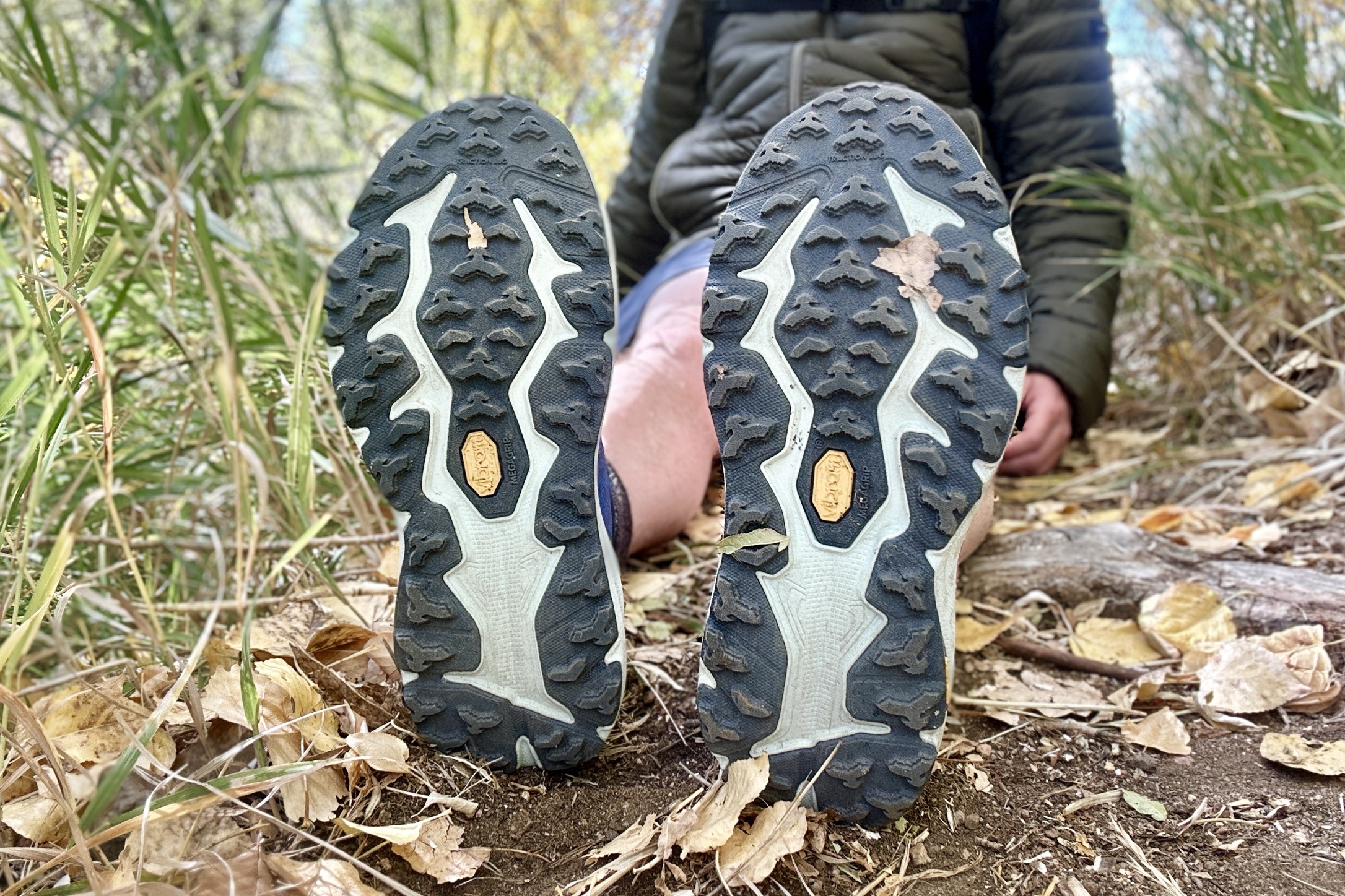 Close up of a pair of running shoes from the bottom to show the tread pattern.