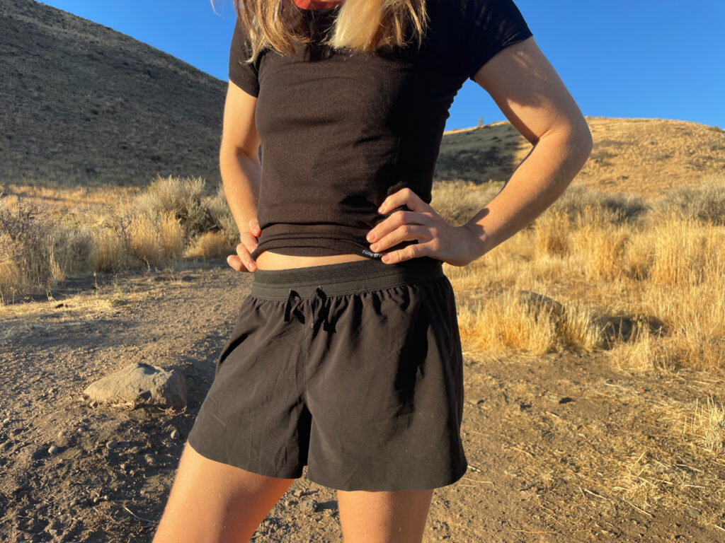 a women in the desert wearing the janji afo middle shorts in black