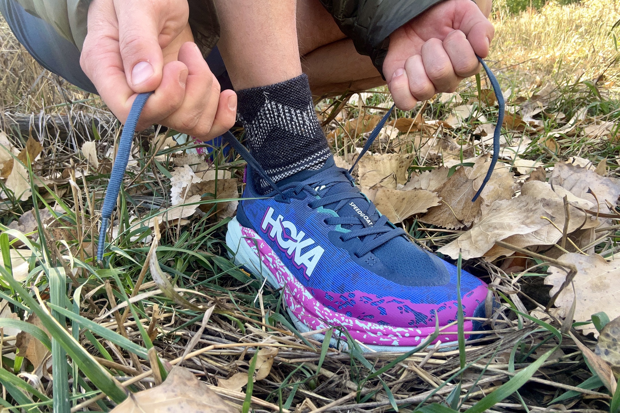 Close up of a person tying a pair of shoes.