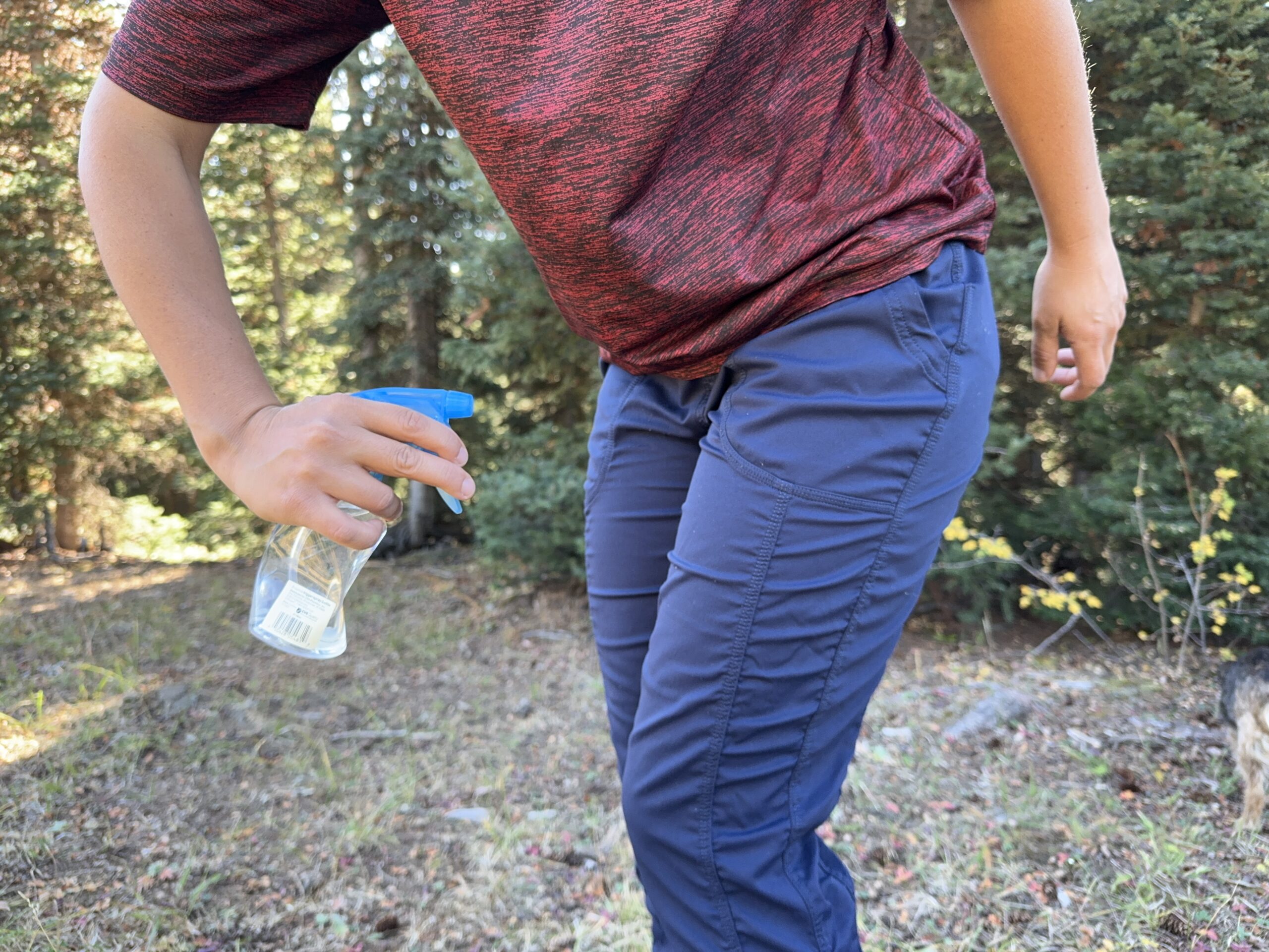 a gear analyst spraying her pants with water to test weather resistance