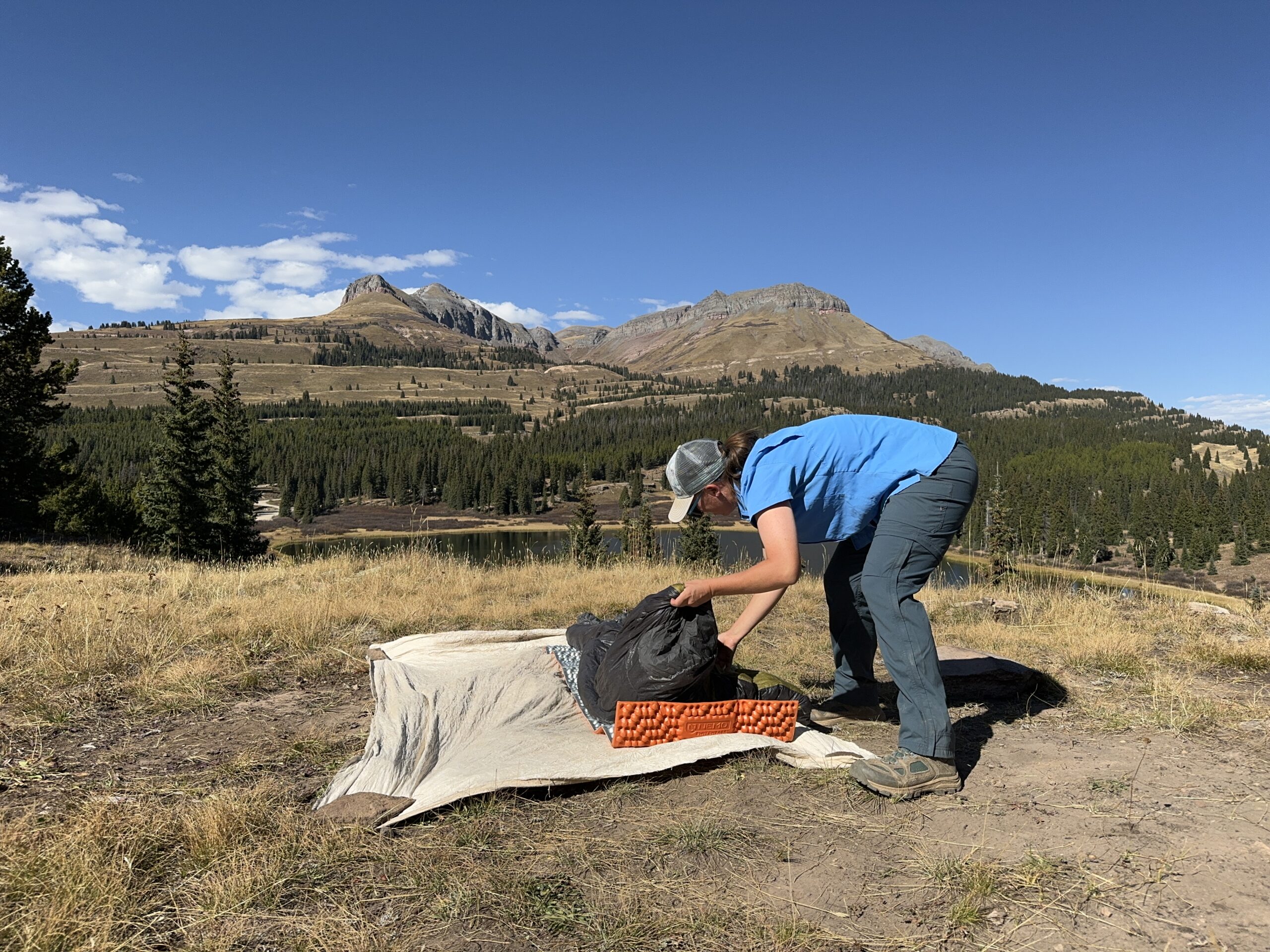 a backpacker setting up camp in the REI Sahara pants