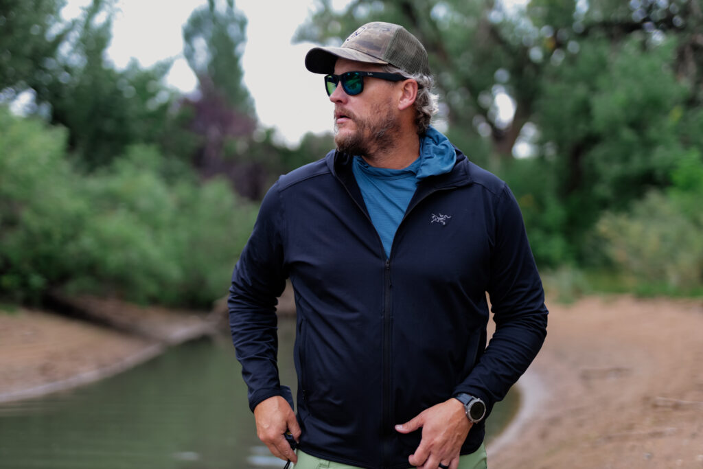 Man hiking on a trail next to a river.