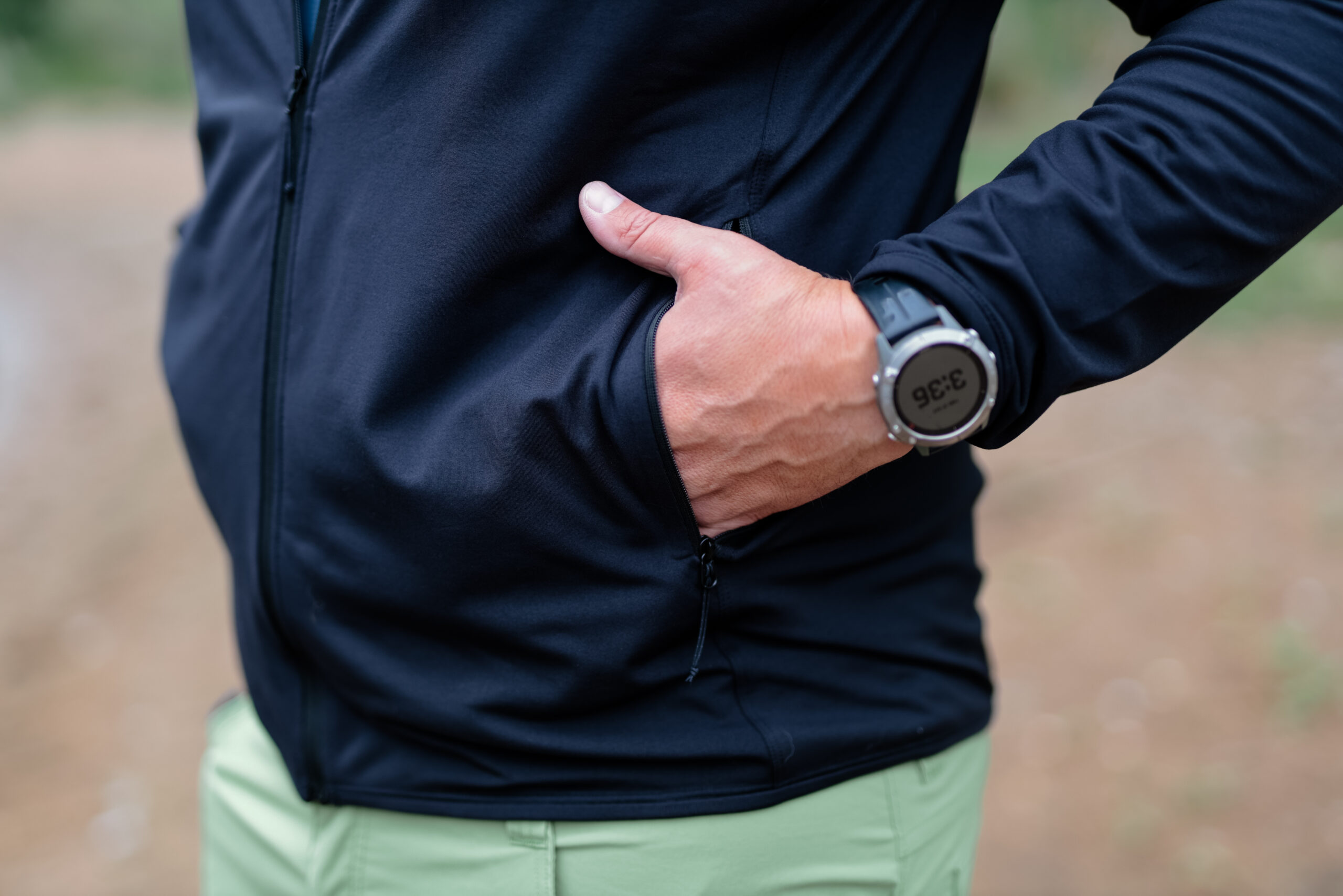 A man's hand in the pocket of a fleece.