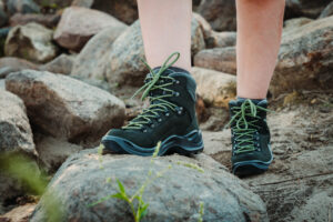 Hiker wearing Lowa Renegade GTX Women's Hiking Boots and crossing some rocks