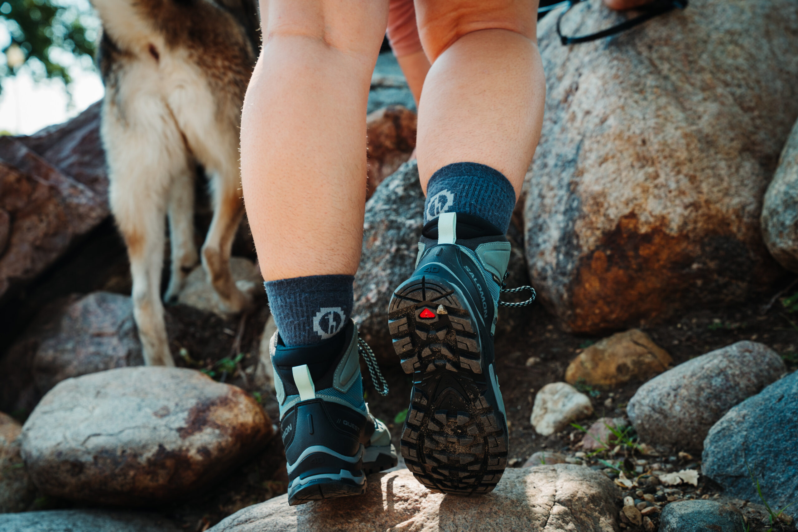 Hiker wearing the Salomon Quest 4 GTX Women's Hiking Boots and walking up a rocky trail.