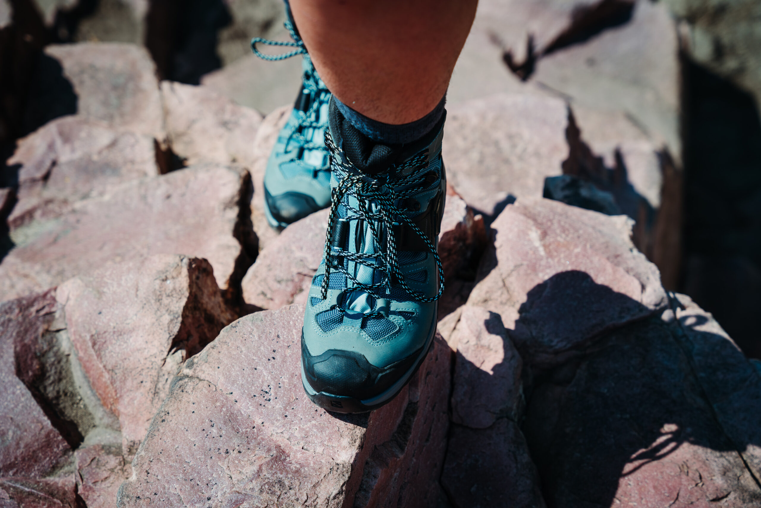 Hiker wearing the Salomon Quest 4 GTX Women's Hiking Boots and walking up a rocky trail.