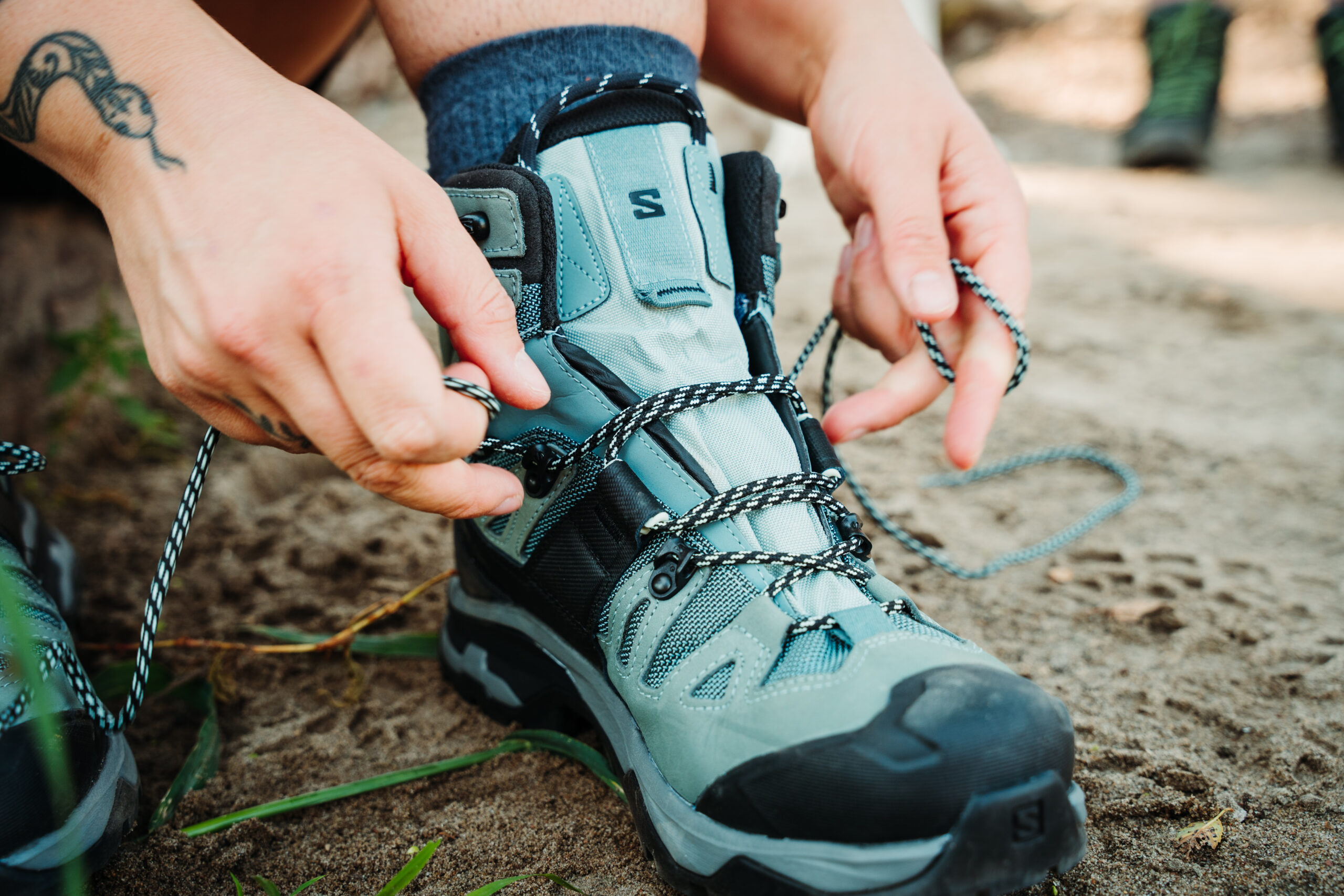 Hiker tying her Salomon Quest 4 GTX Women's Hiking Boots