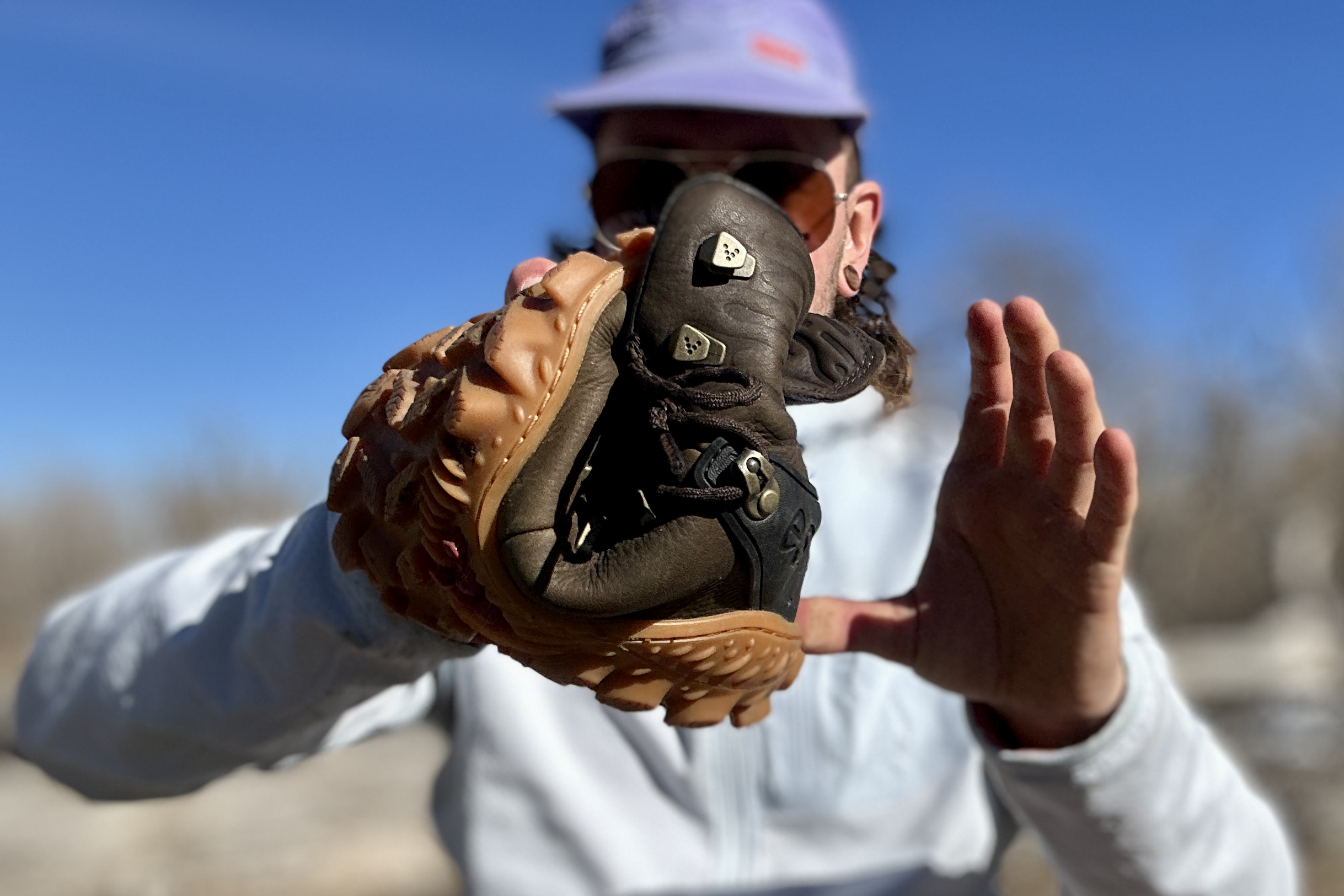 Close up image of a boot rolled up into a small ball held by a person.