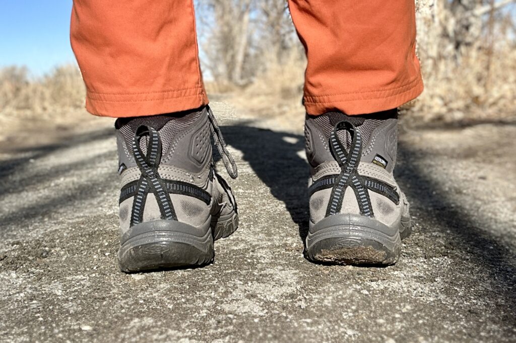 Close up image from knees down of hiking boots from the back.