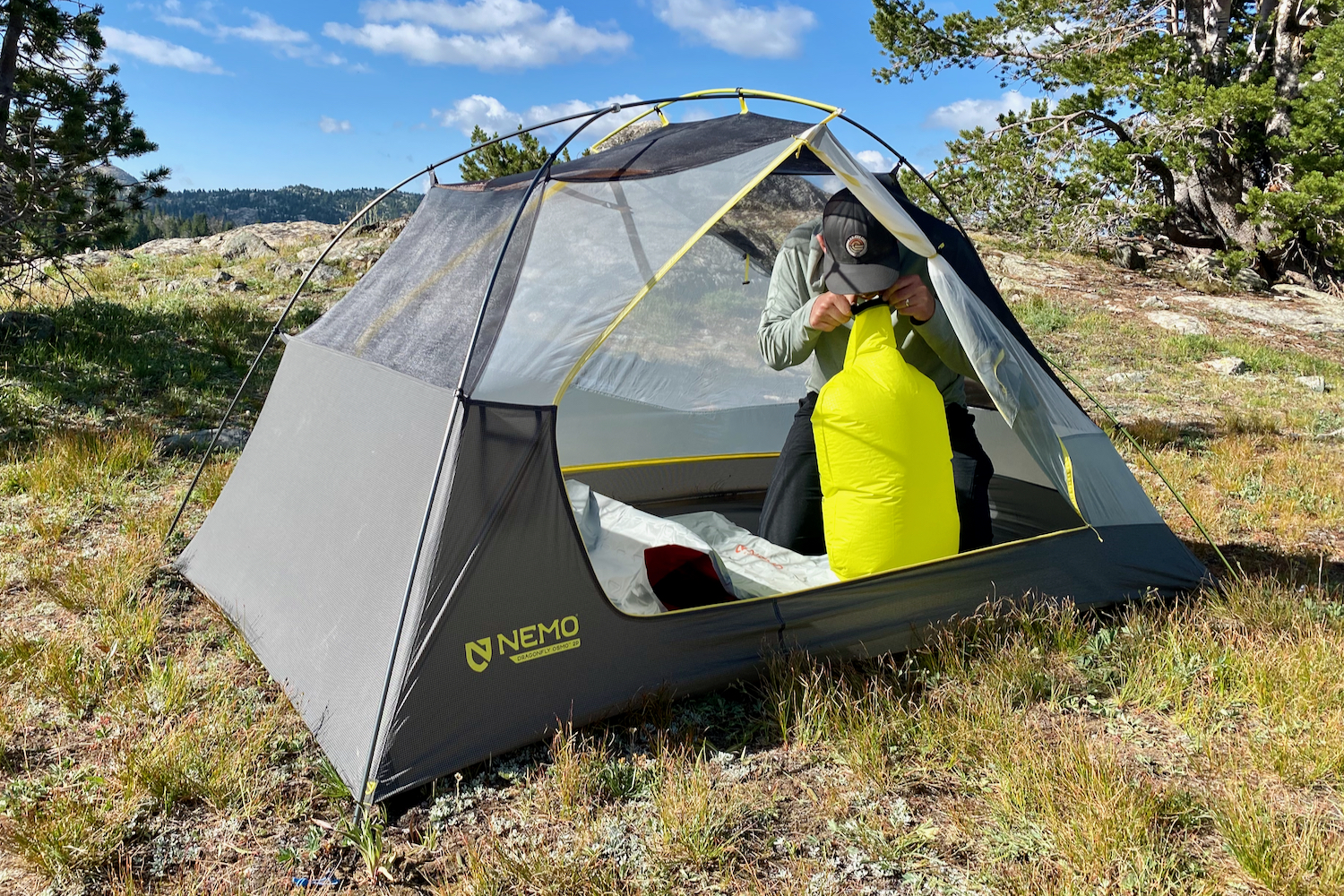 a backpacker adds air to the pump sack to inflate their nemo tensor all-season sleeping pad