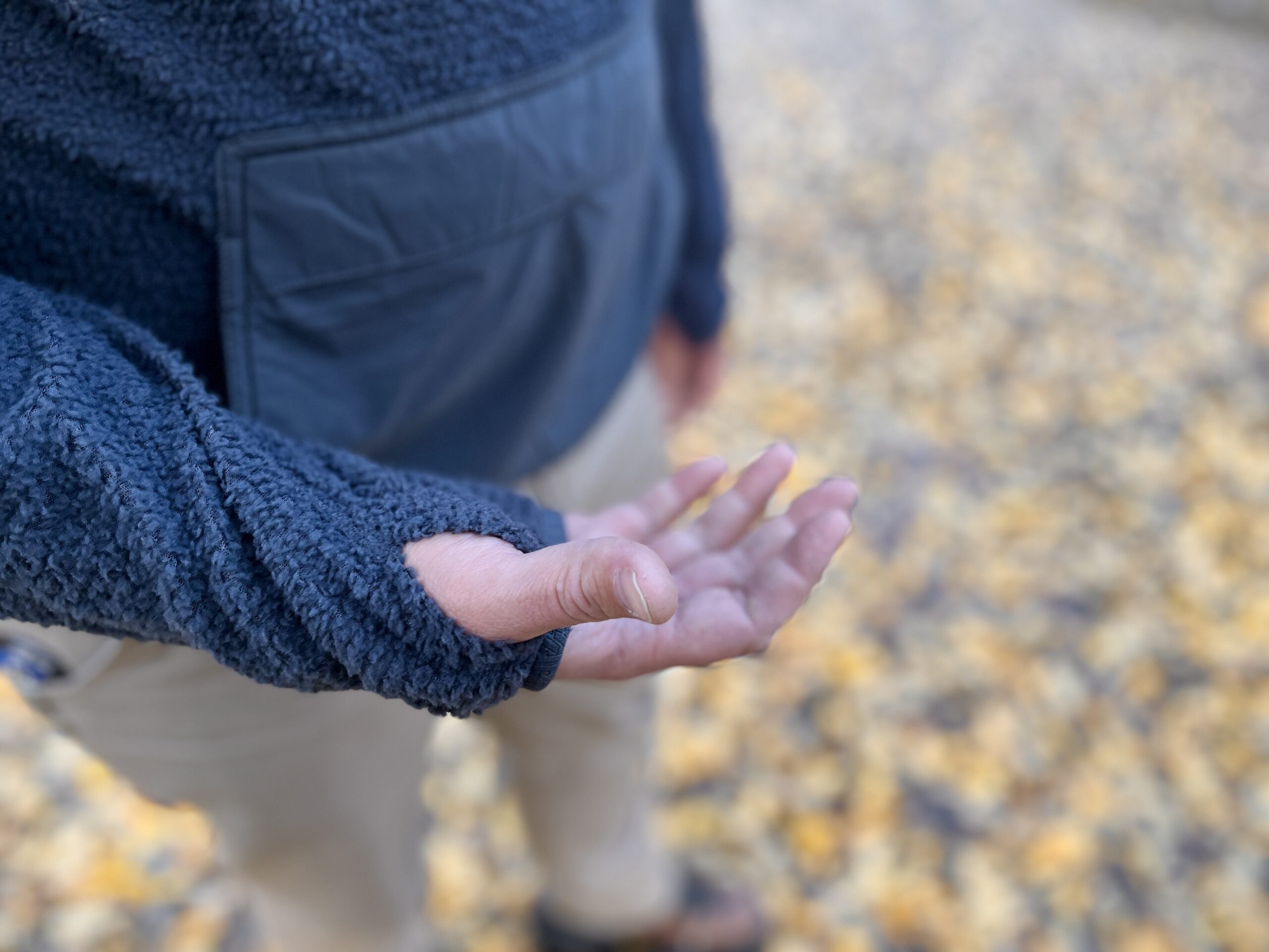 a close up of a mans hand with his thumb through the thumbhold on the eddie bauer super sevens fleece pullover