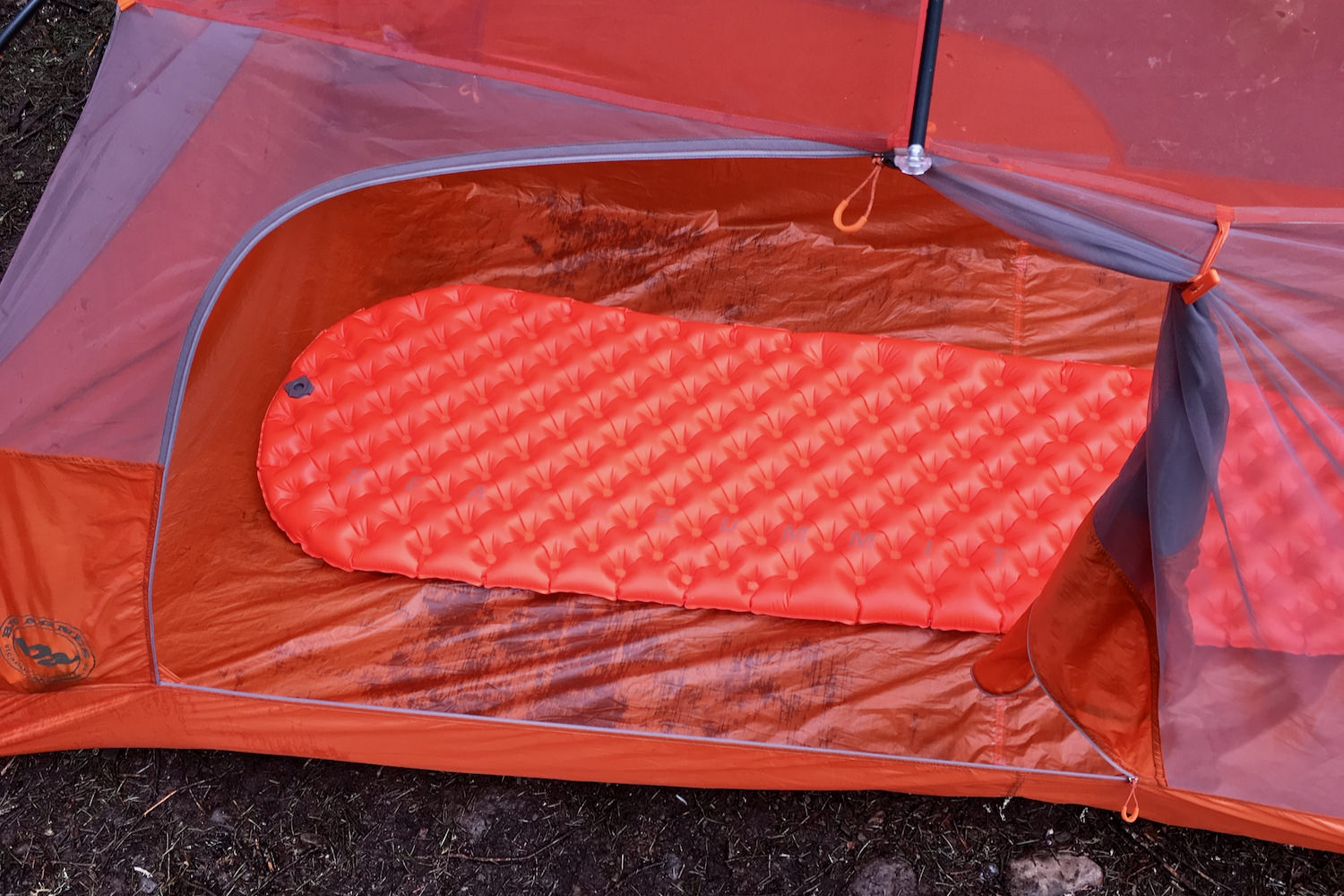 a view from outside a backpacker's tent with the tent door unzipped and a sea to summit ultralight insulated sleeping pad inflated on the inside.