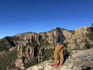 A person wearing the Ferrosi pants is standing at an overlook peering out over a canyon.