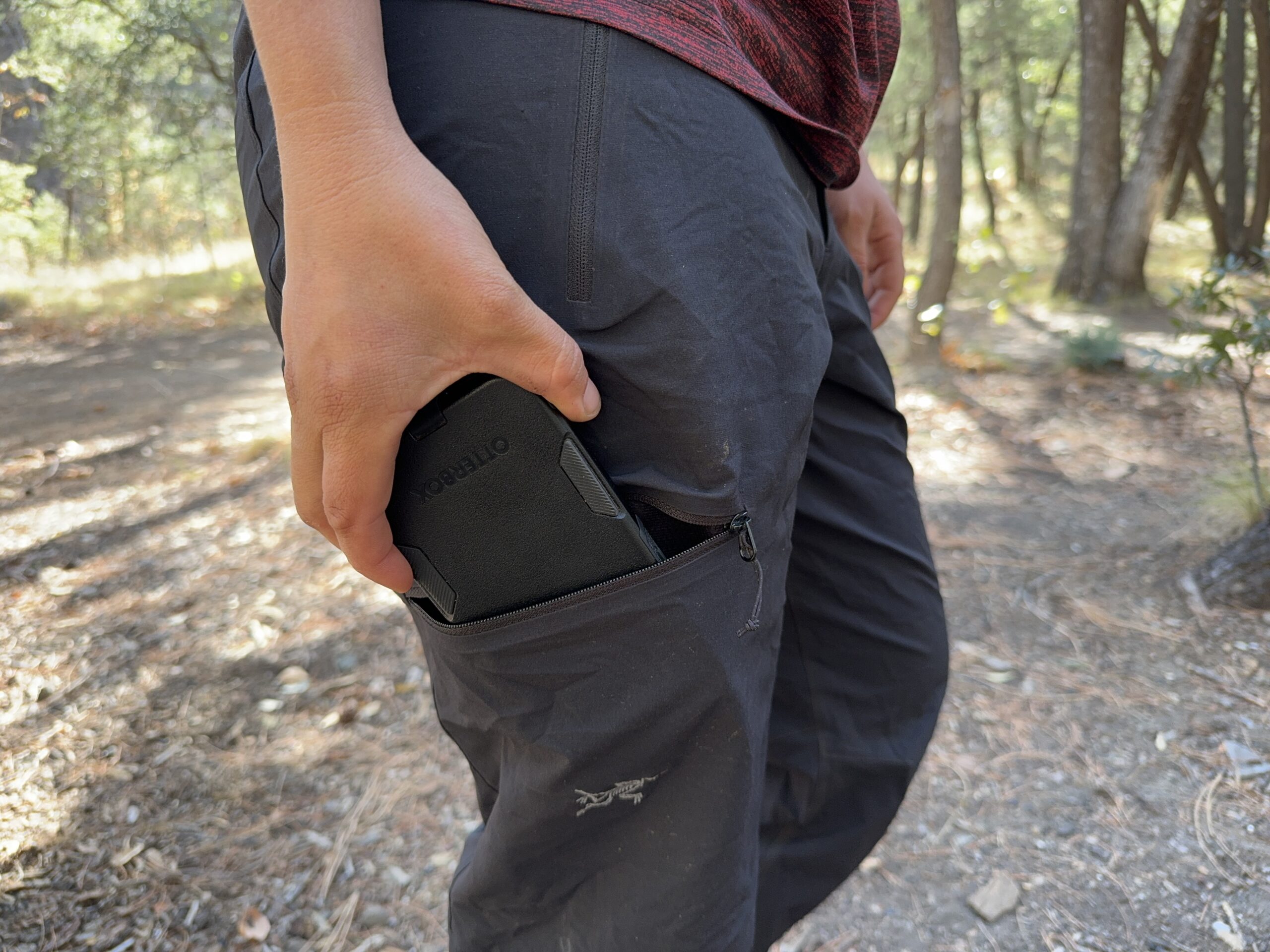 Close up of a phone being placed in the leg pocket of the Gamma pants.