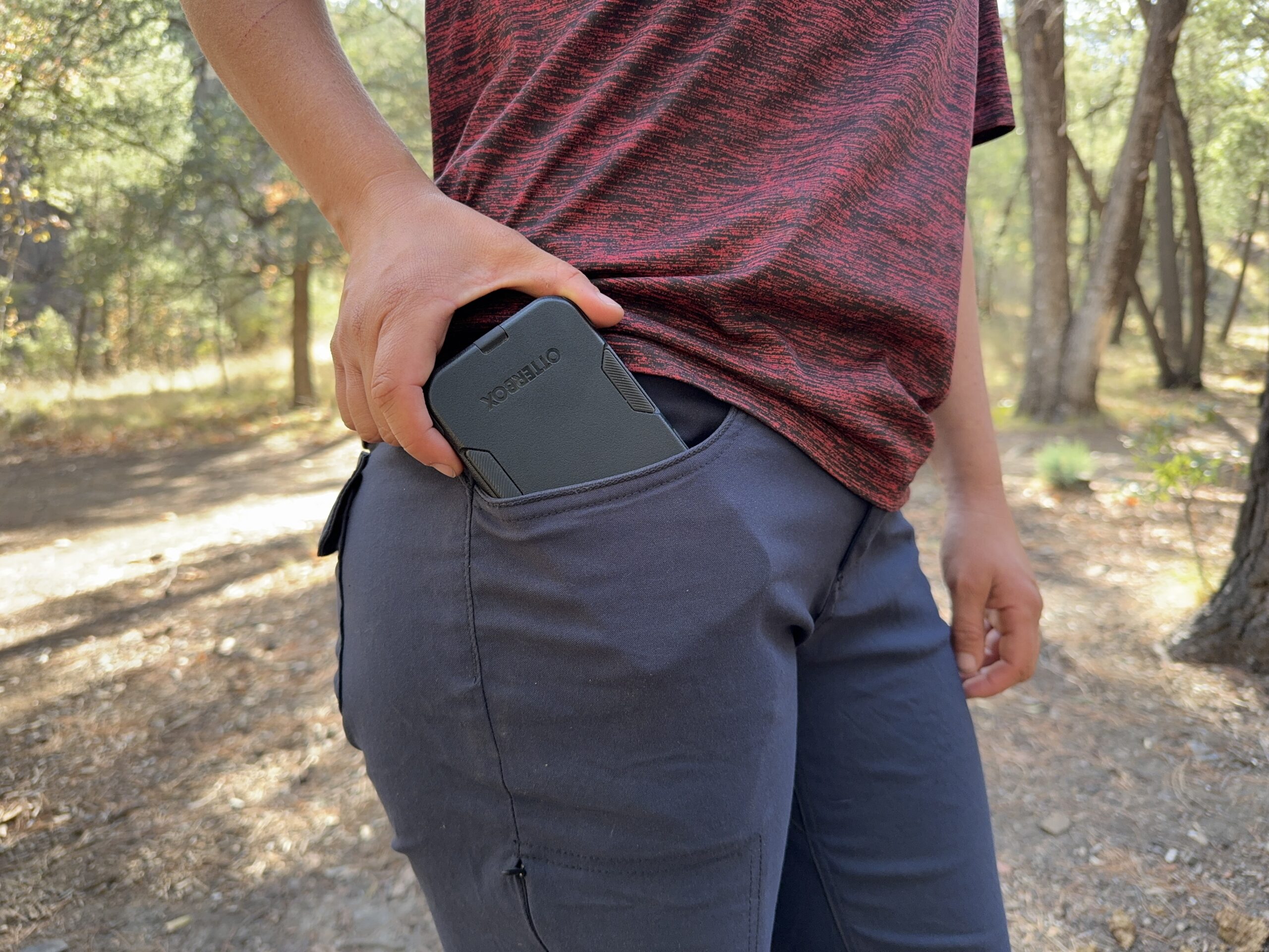 Close up of a phone being placed in the hip pocket of the Halle pants.