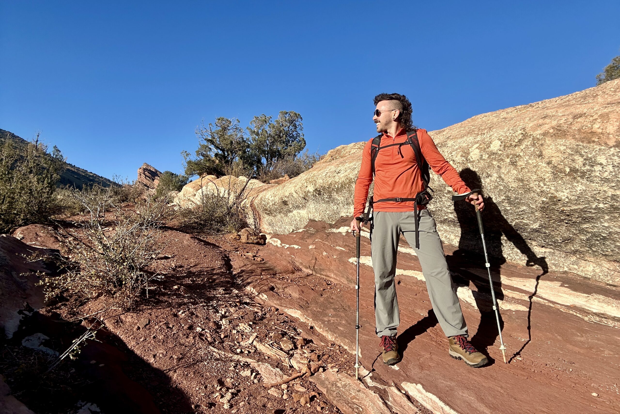 A man stands in a desert setting looking off camera.