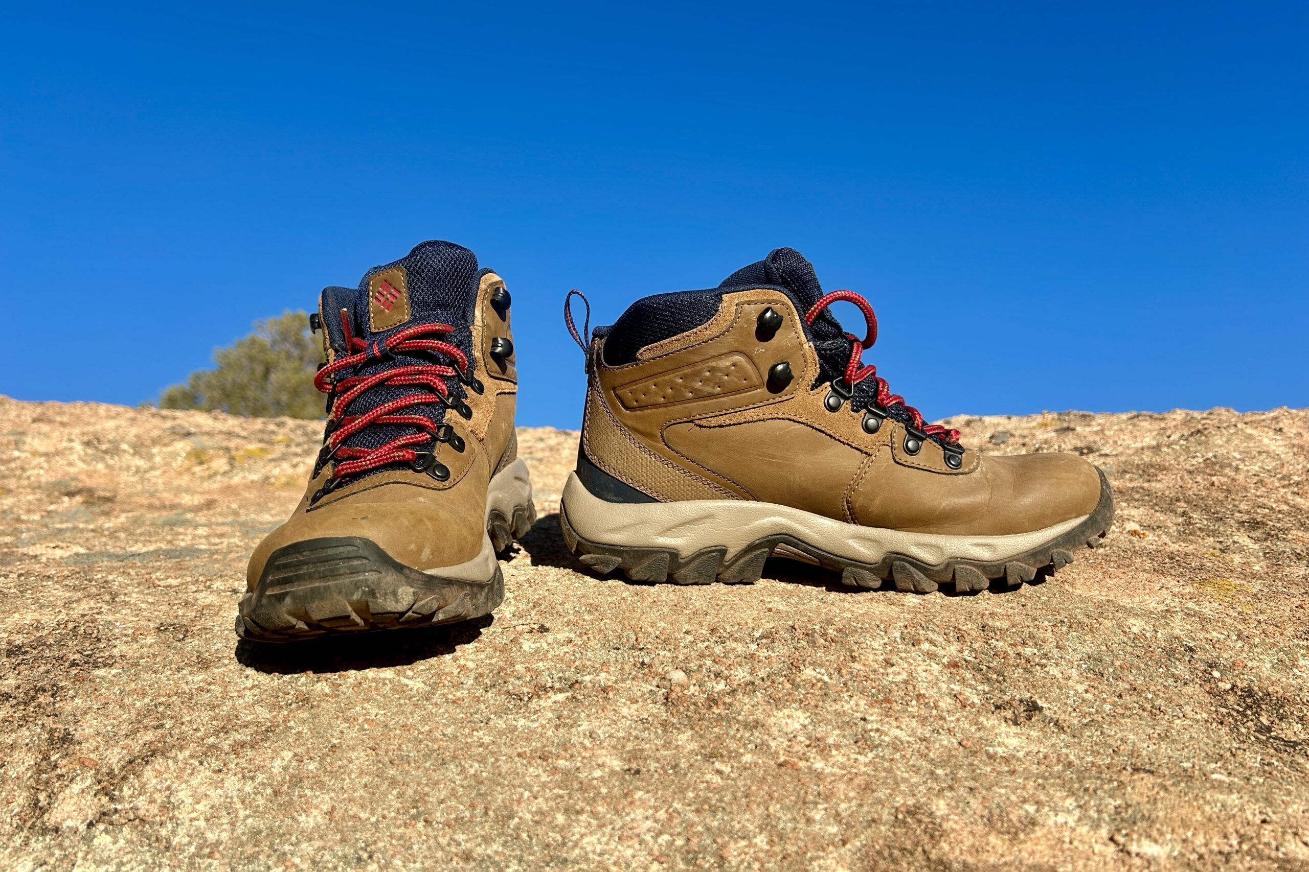 Close up of a pair of hiking boots posed on a rock.