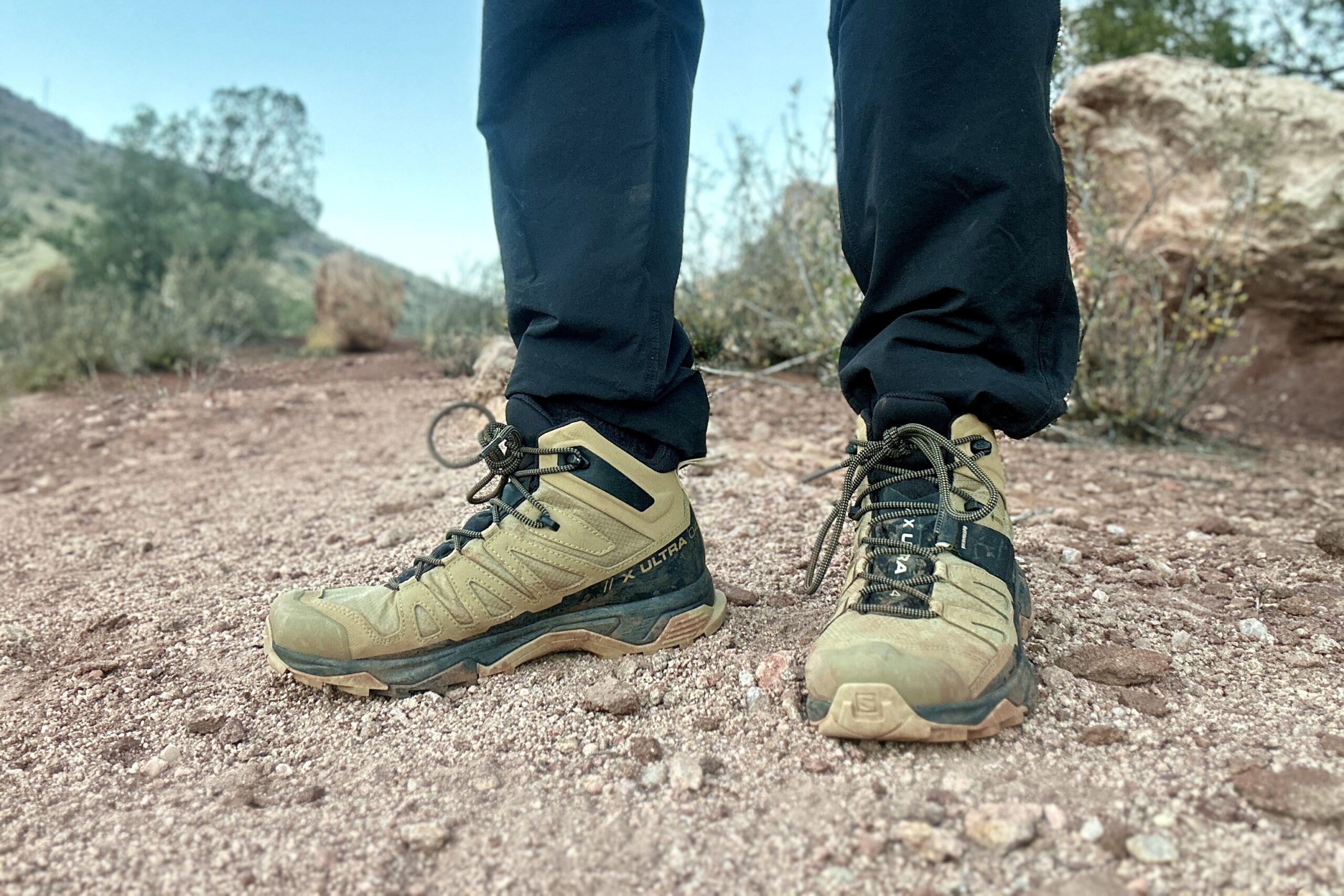 Close up from knees down of a person walking in hiking boots on gravel.