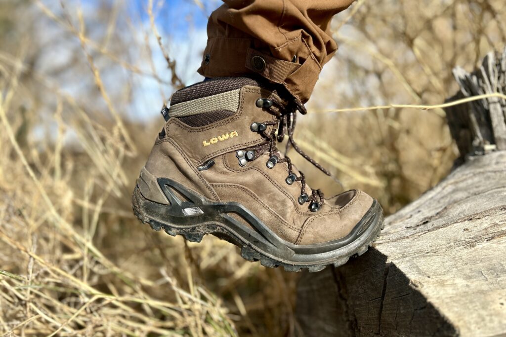 Close up side profile of a brown boot flexing as a person hikes.