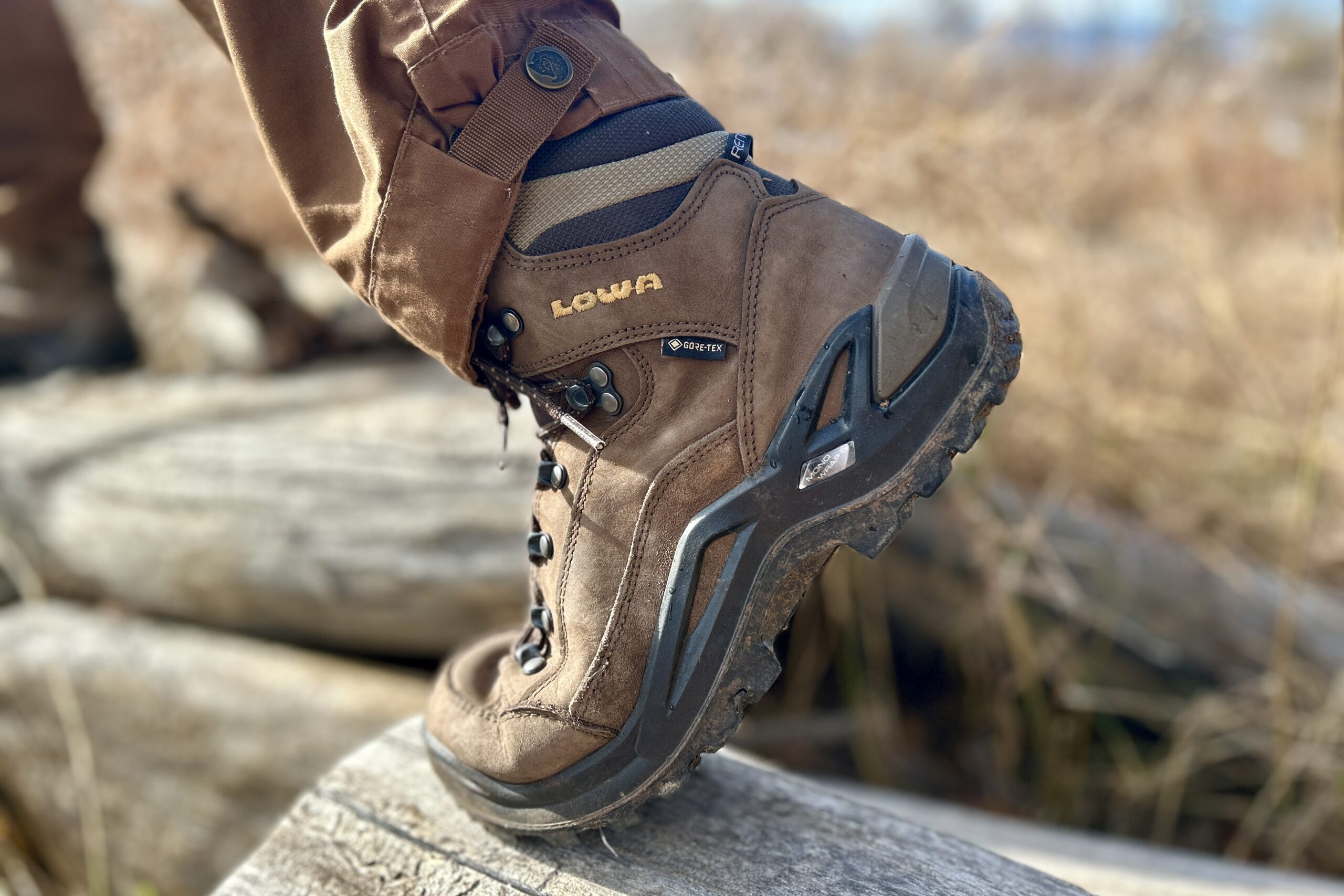 Close up side profile of a brown boot flexing as a person hikes.