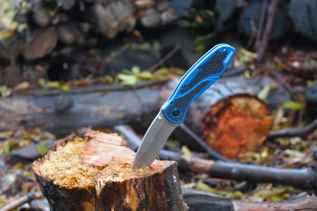 Kershaw Blur pocket knife stuck into a in a log