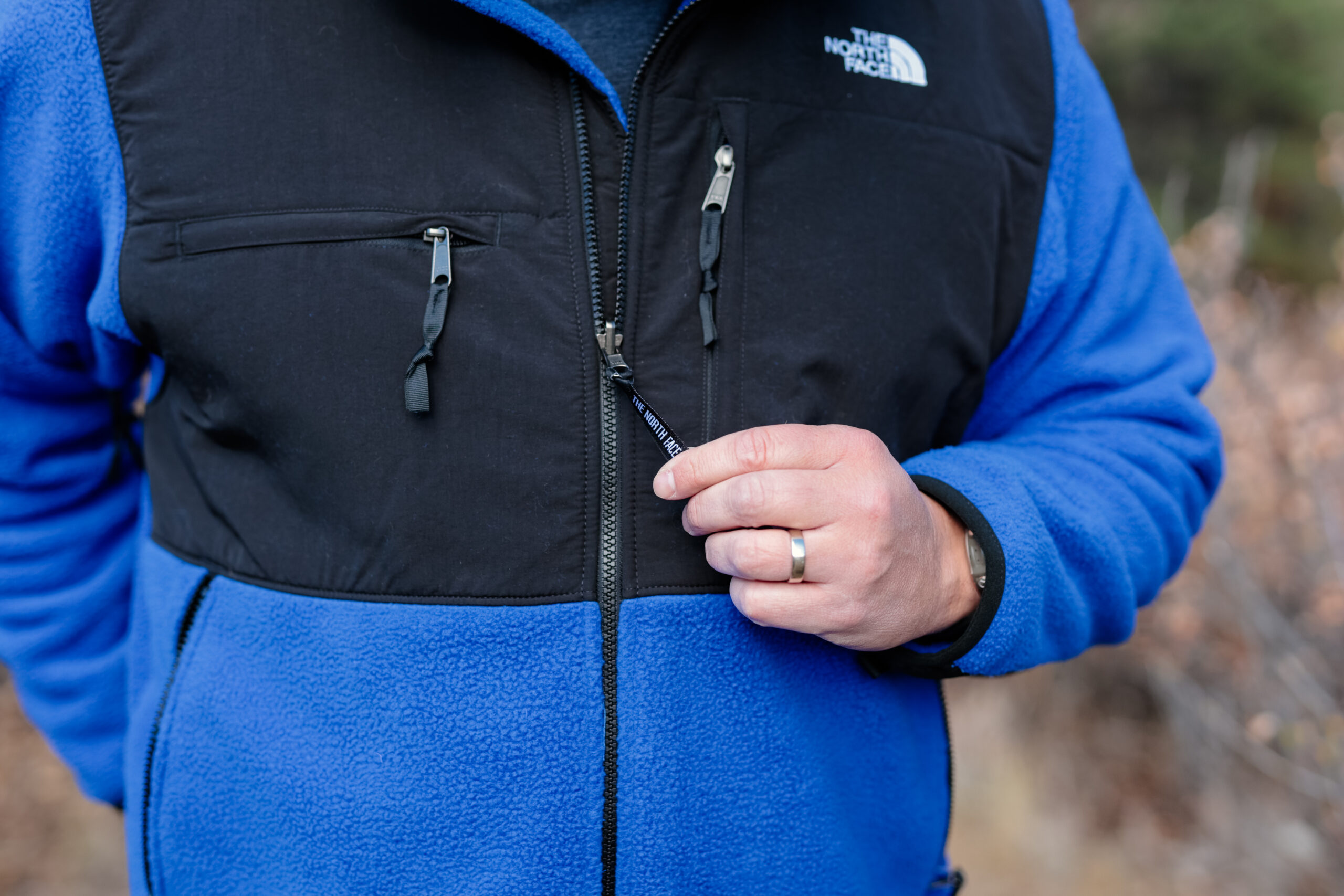 Man's hand pulls zipper on a fleece.