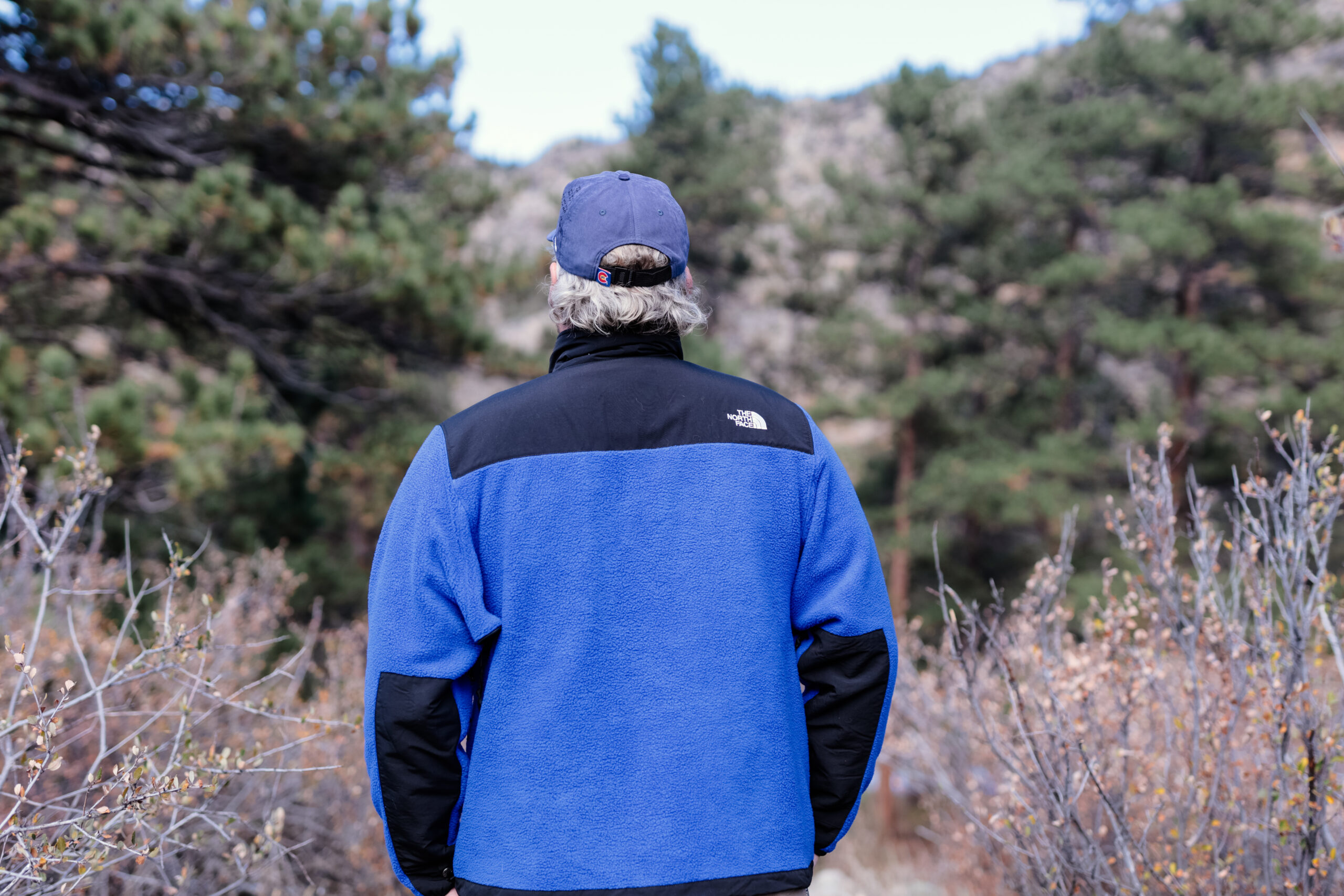 The back of a man in a blue fleece.