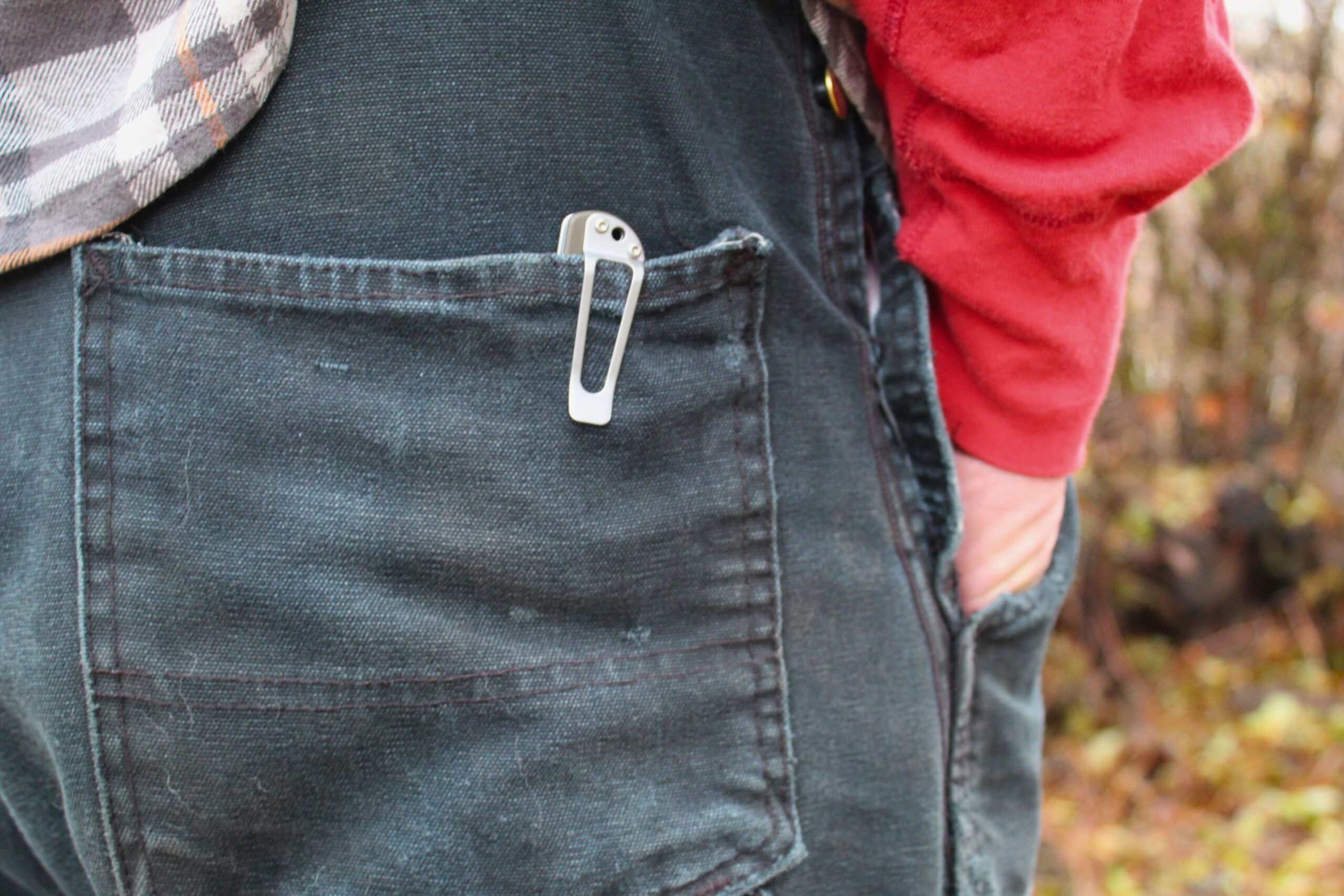 The SOG Twitch II in a back pocket of overalls to show the pocket clip