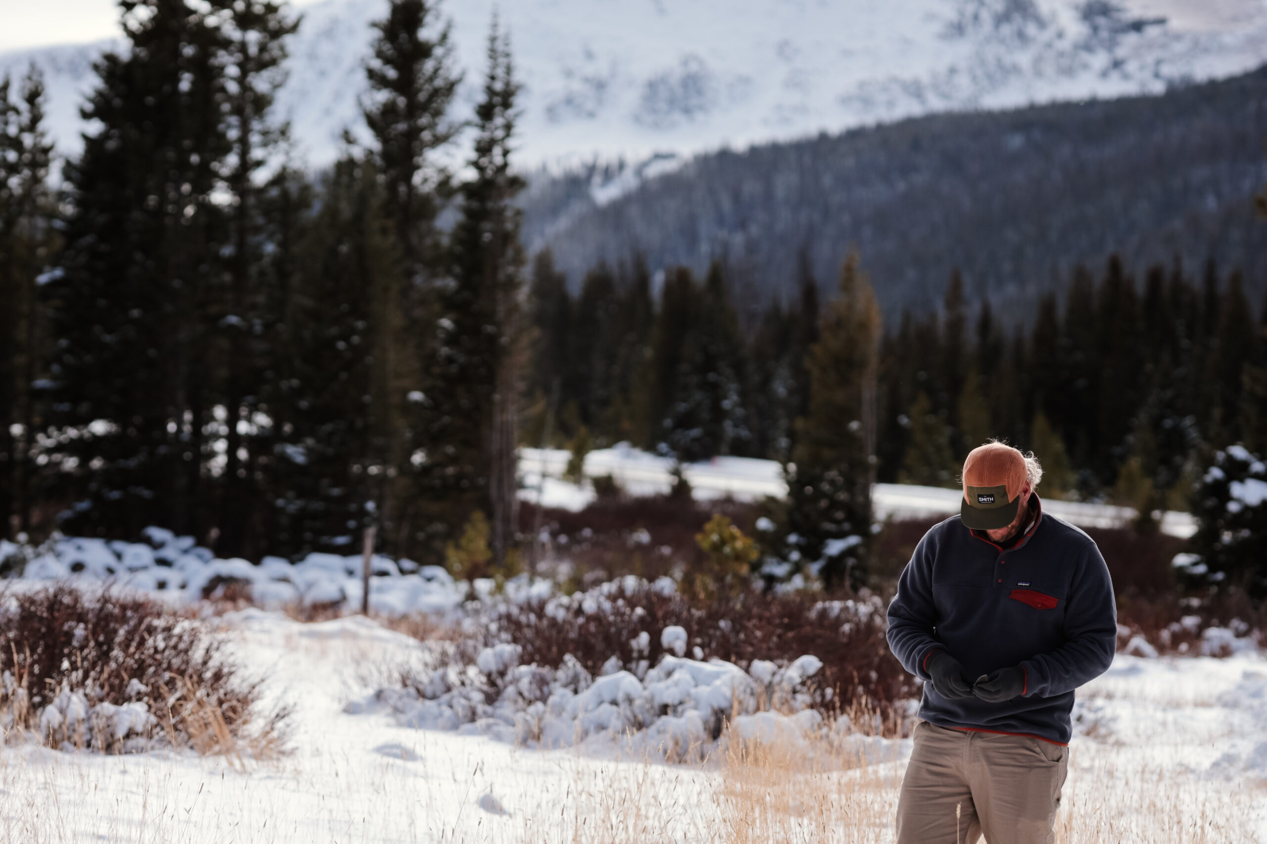 A man stands in a snowy meadow.