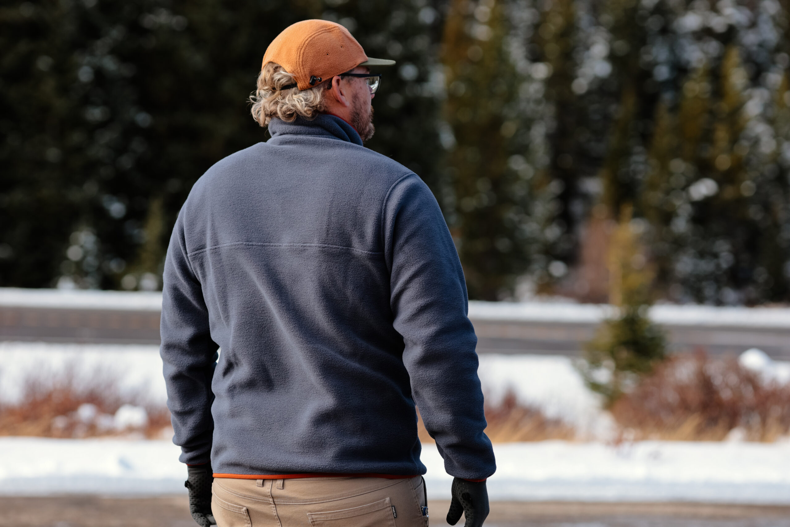 The back of a man in a blue fleece.