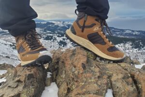 A side shot of a pair of winter boots on a rock.