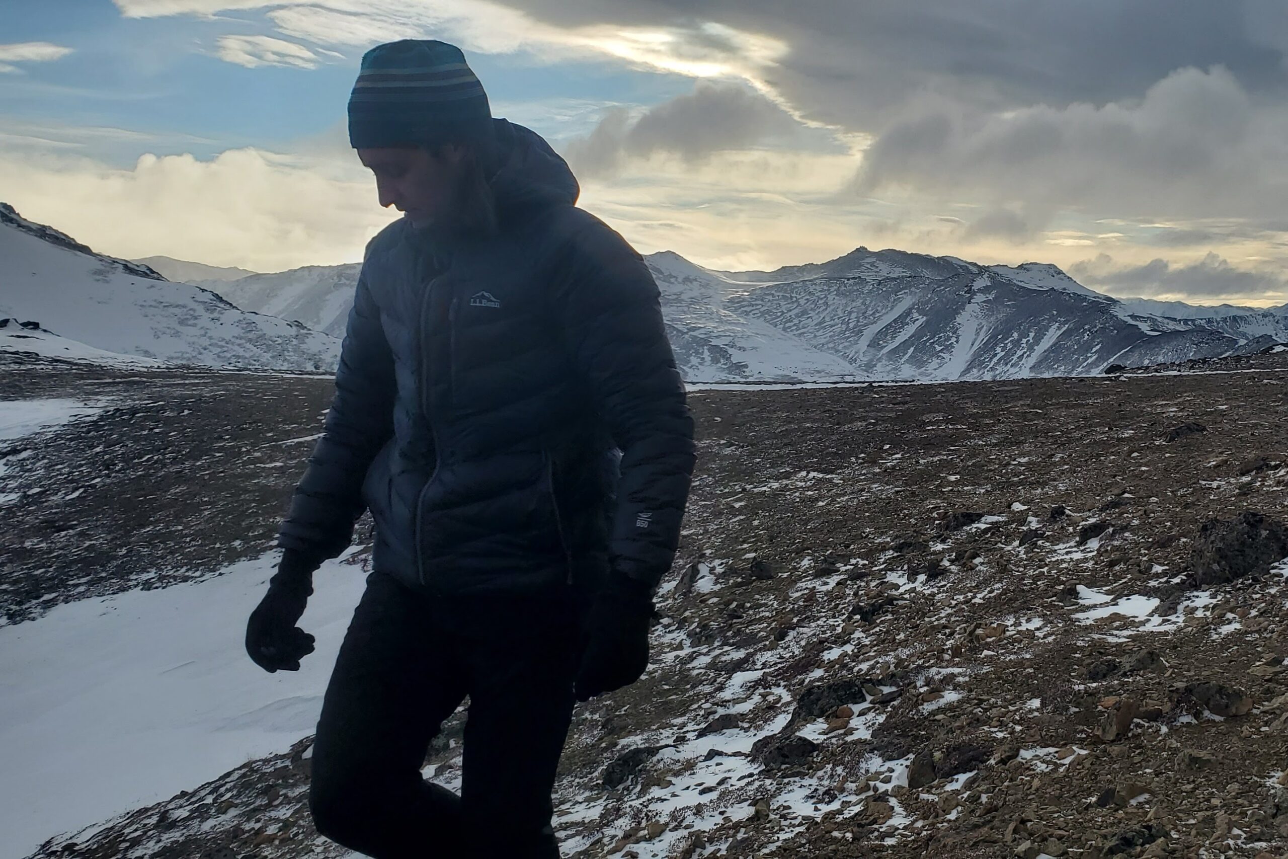 A man walks towards the camera through snowy tundra