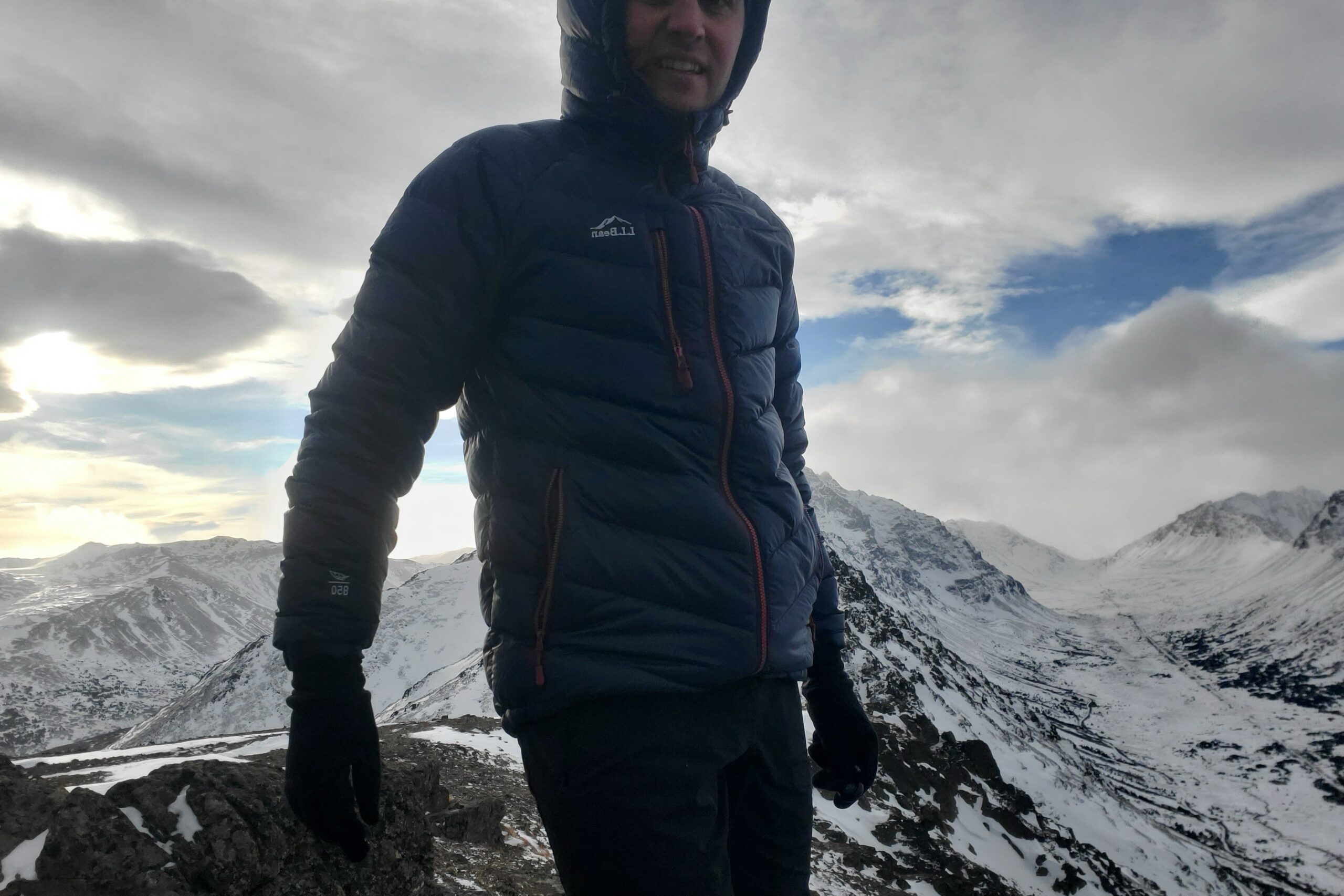 A man stands on a snowy mountaintop